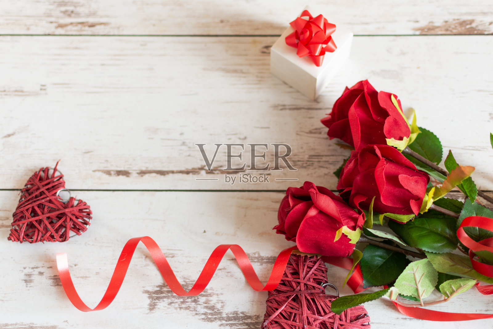 红玫瑰和心形木背景。照片摄影图片