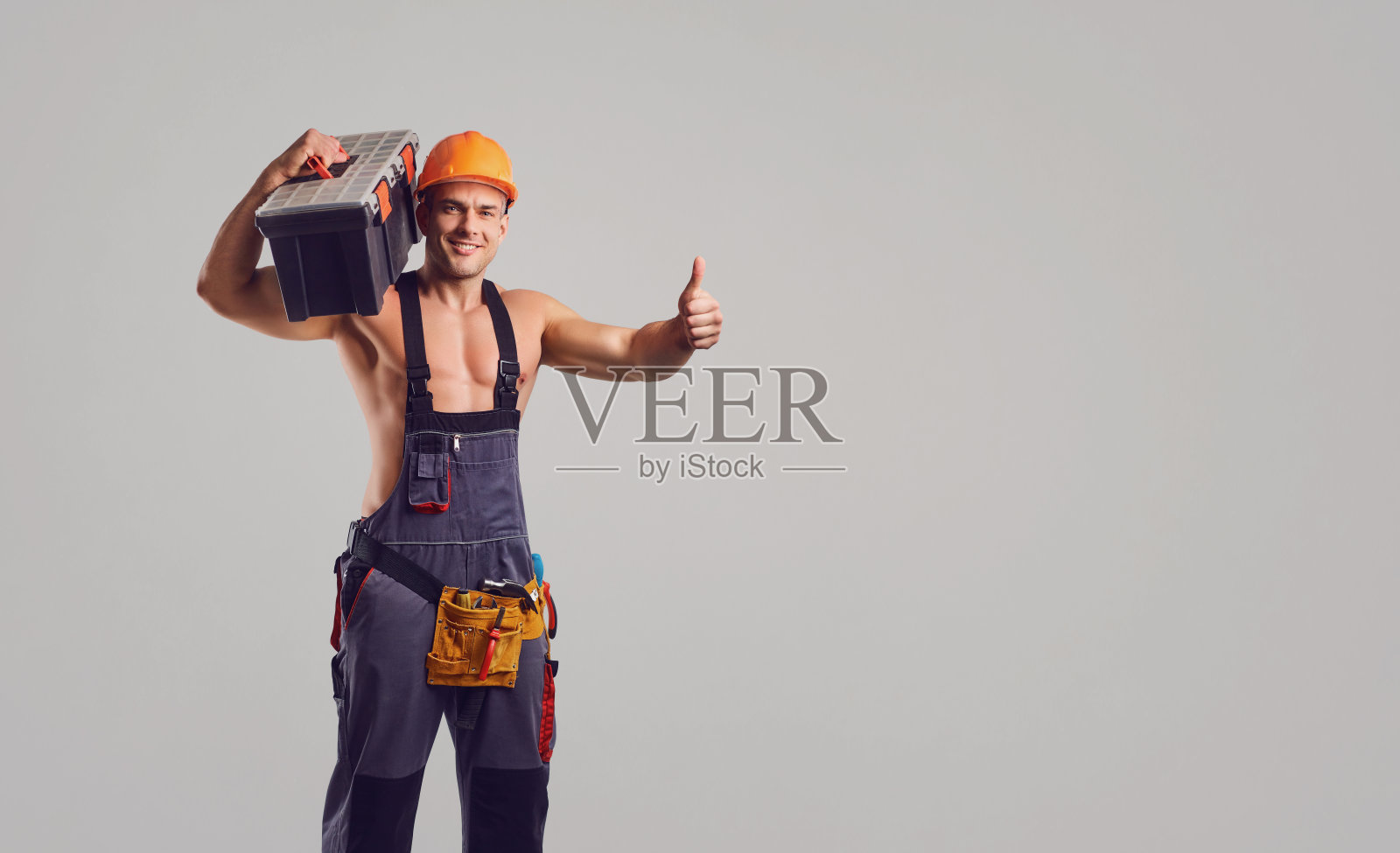 修理工在灰色的背景上微笑。照片摄影图片