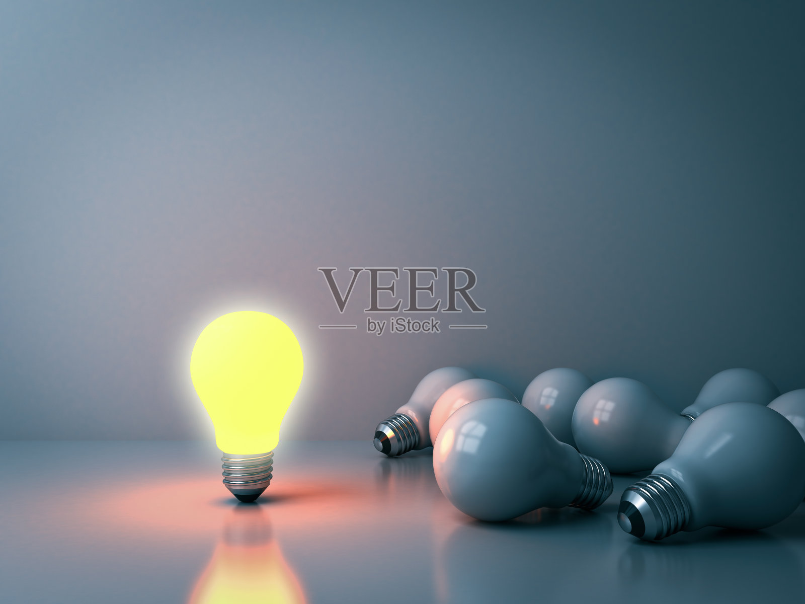 在黑暗的房间背景中，一个发光的灯泡从未点亮的白炽灯泡中脱颖而出，反射出领导能力和不同的商业创意概念照片摄影图片