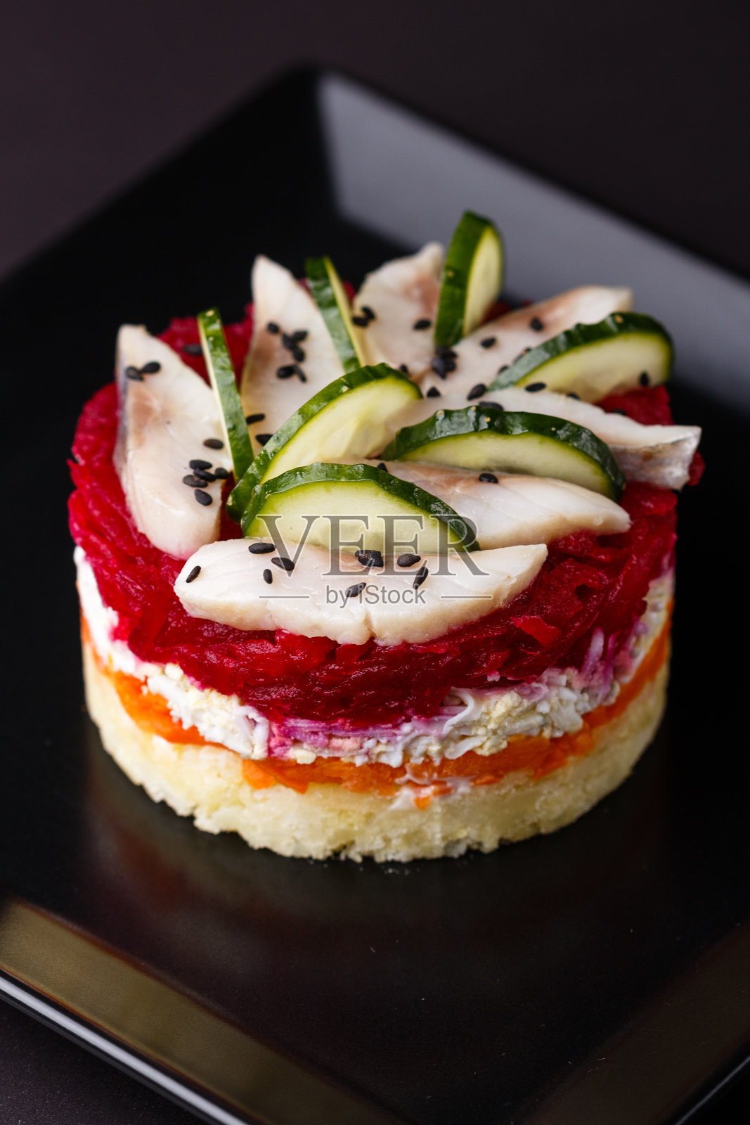 深色背景下毛皮大衣下的俄罗斯色拉鲱鱼照片摄影图片