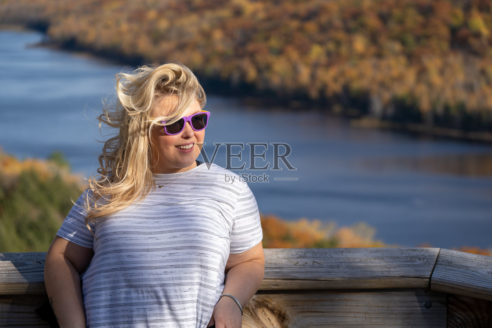 可爱的金发女郎在密歇根州豪猪山野生国家公园的云湖上摆姿势，眼睛远离镜头照片摄影图片