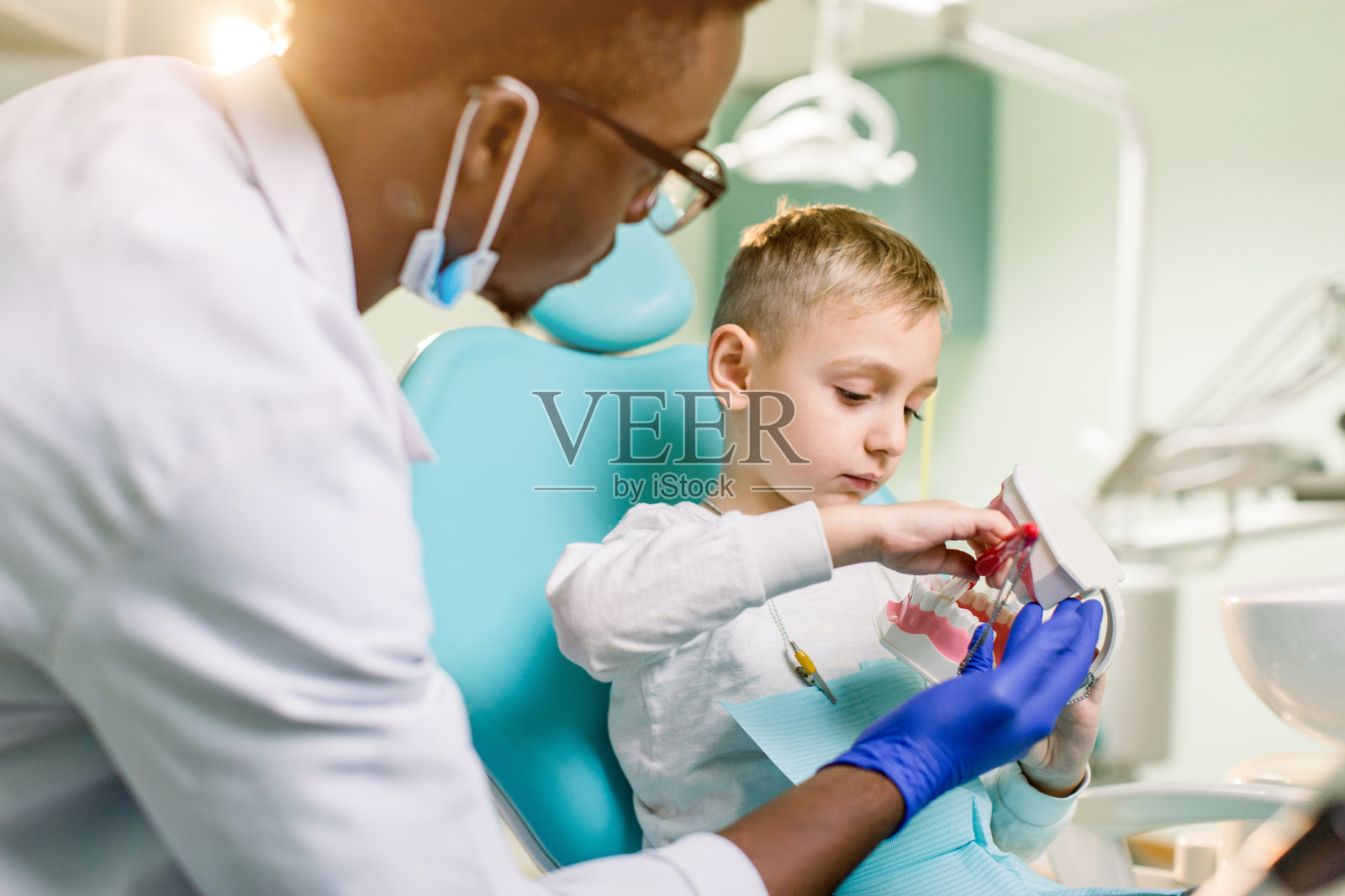 牙医正在检查男婴的牙齿。预防龋齿、乳牙、儿科照片摄影图片