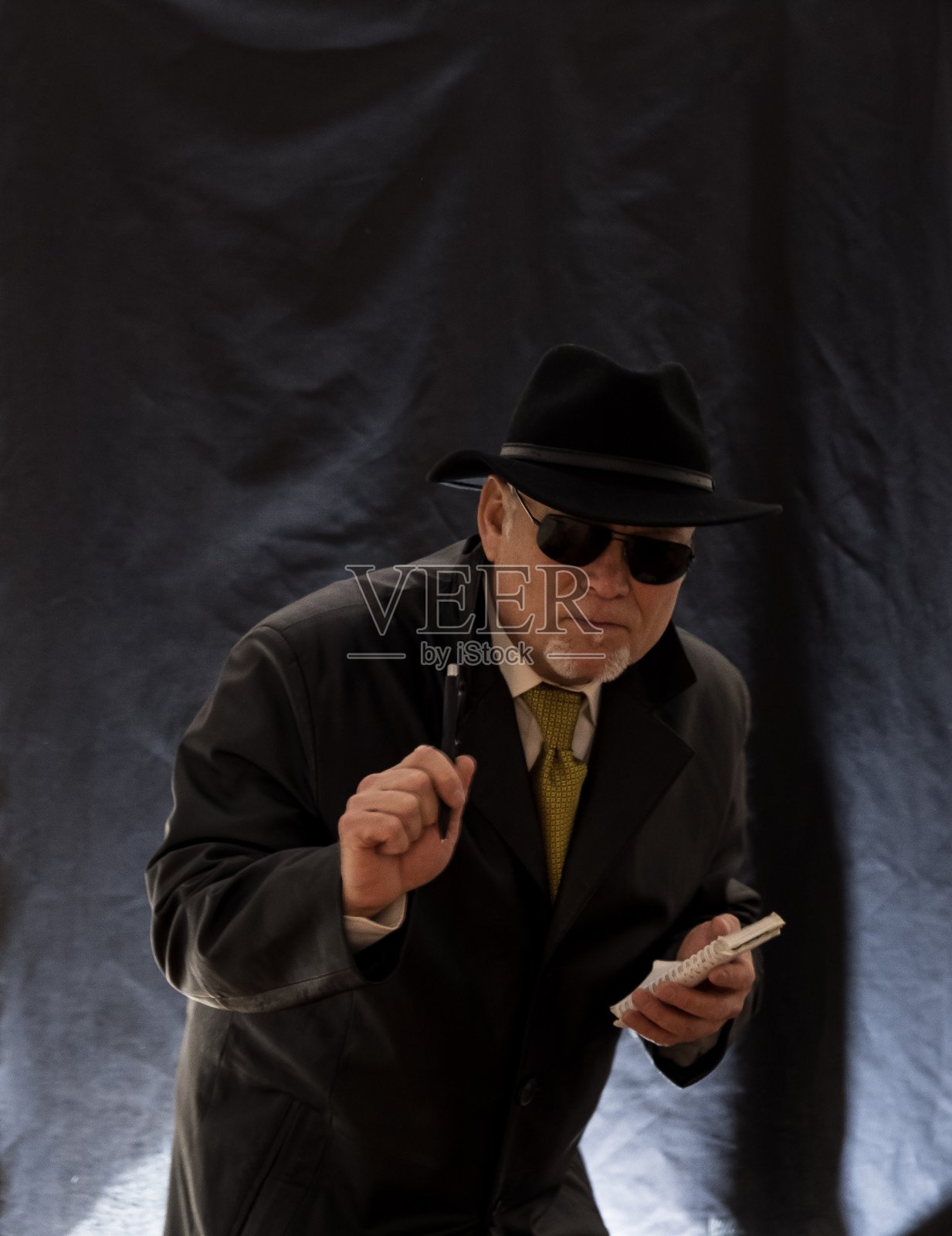 一个人是间谍，侦探，在笔记本上记录观察。照片摄影图片