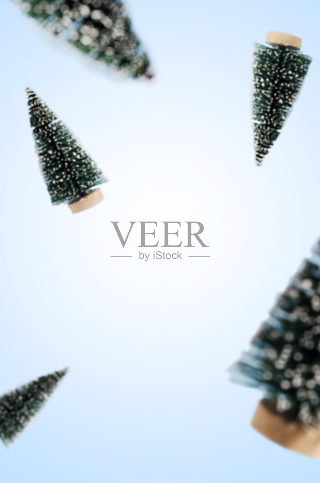 装饰塑料圣诞冷杉树在蓝色的背景。新年节日垂直背景。圣诞假日创意构图与特写云杉。寒假装饰照片摄影图片