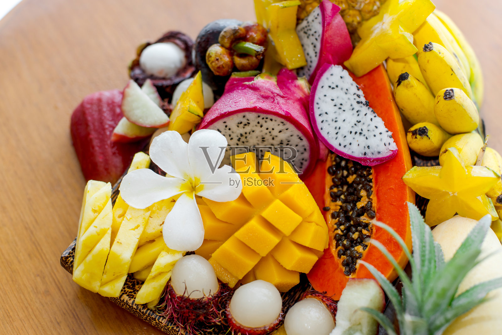 多汁熟透的泰国热带水果放在木盘上。照片摄影图片