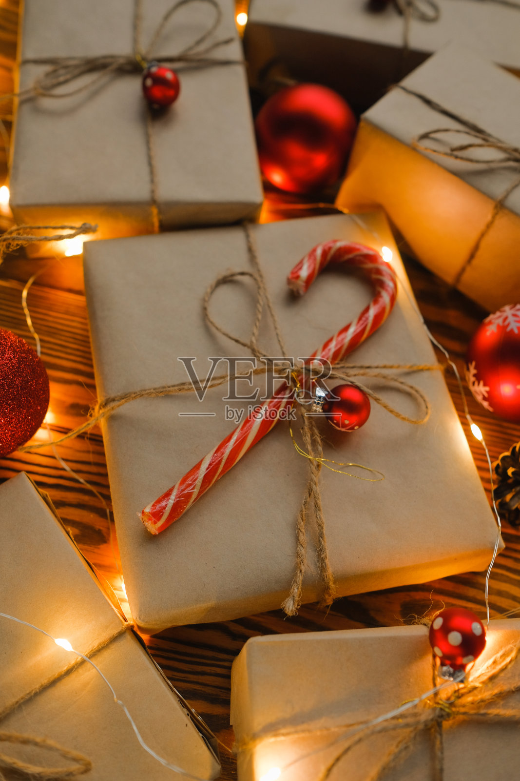 圣诞礼物、花环和圣诞玩具放在一张木桌上。照片摄影图片