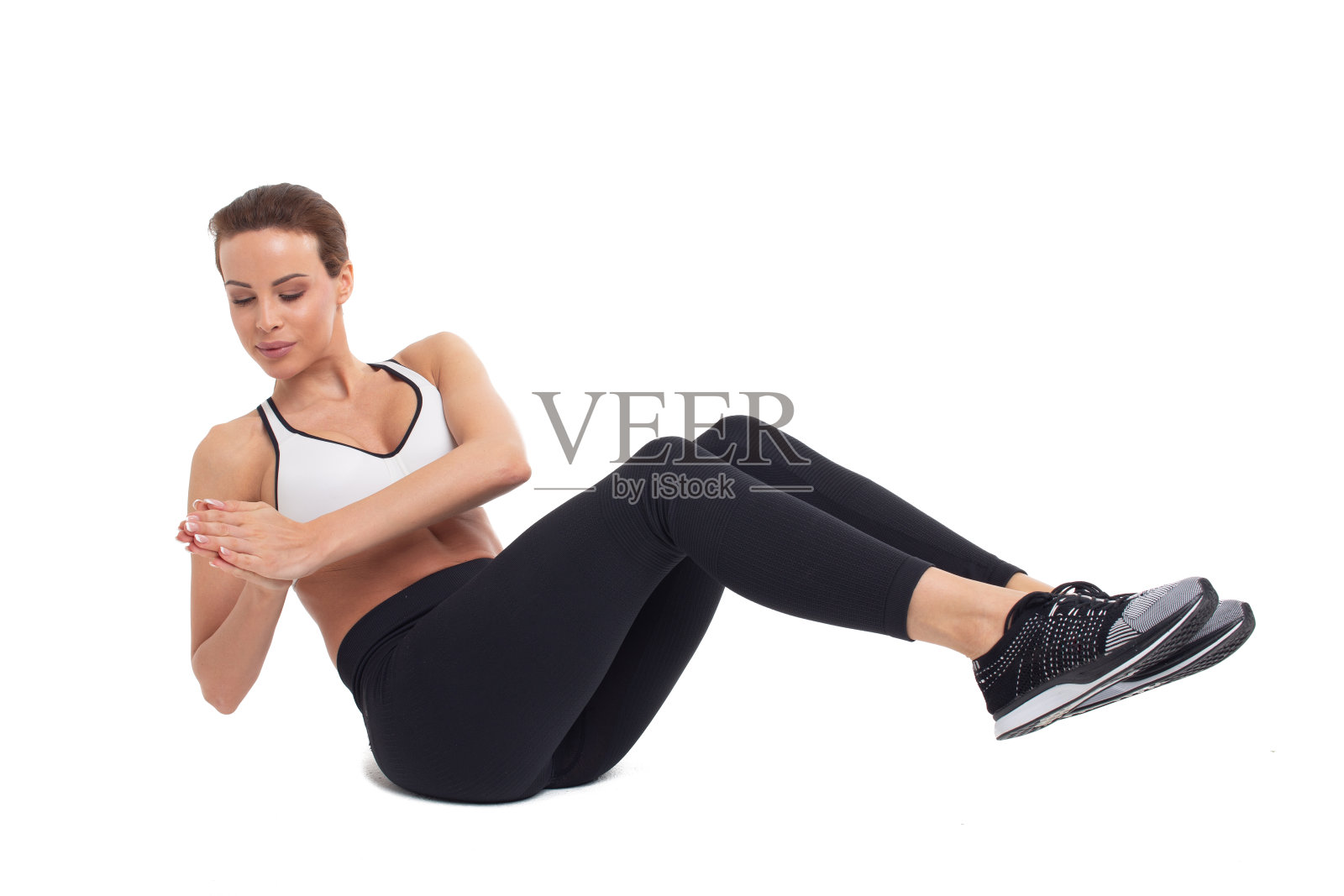 年轻女子在做腹肌练习，俄罗斯扭摆，单独练习照片摄影图片