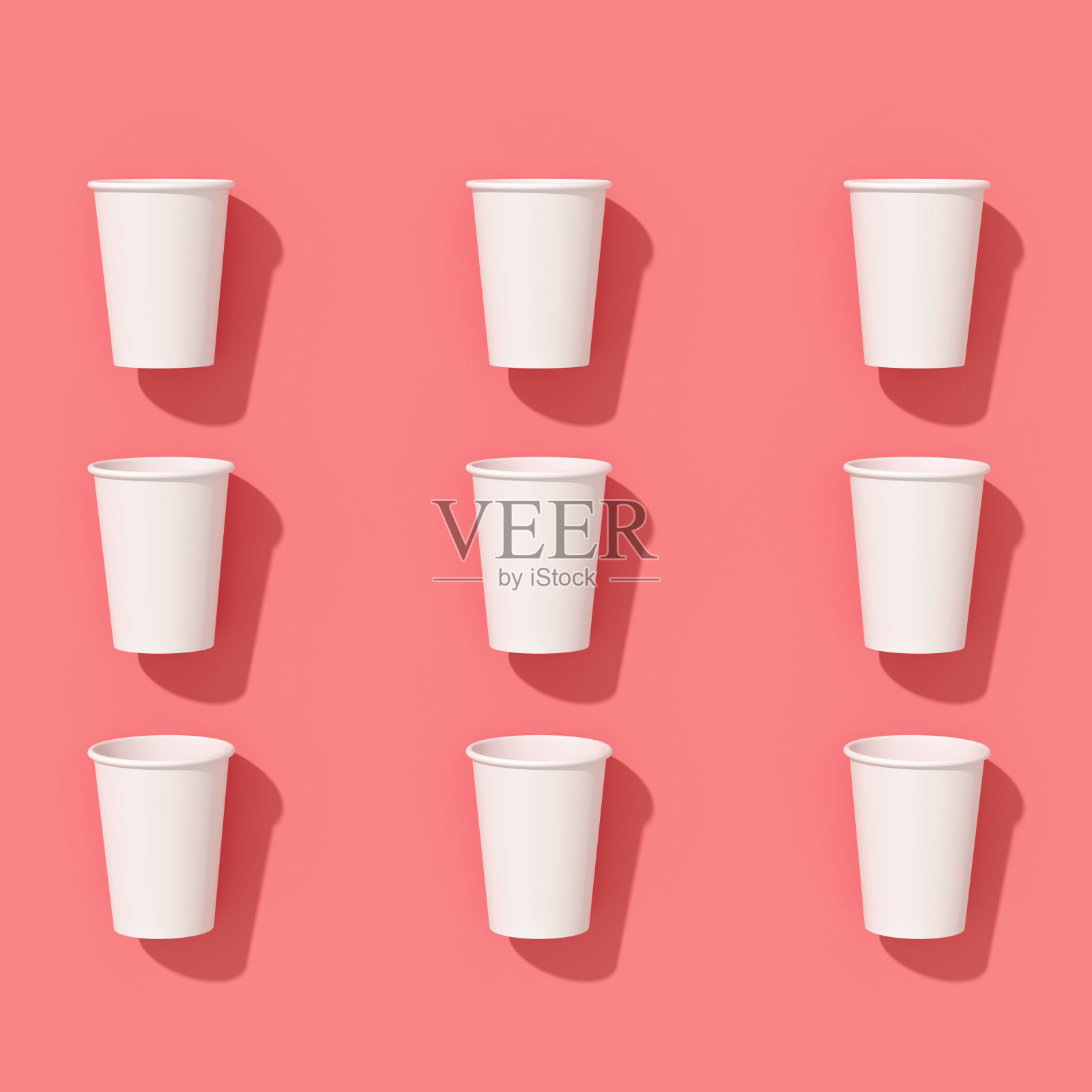 一次性空纸杯的图案铺在一个有坚硬阴影的背景上照片摄影图片