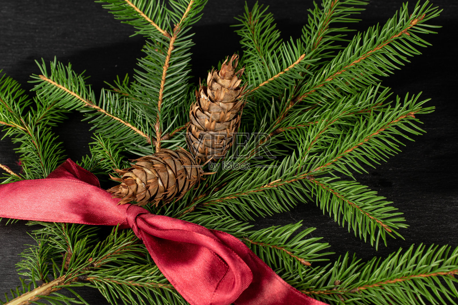 灰色的石头上的圣诞树树枝照片摄影图片