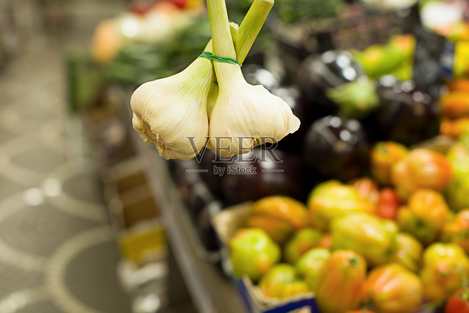 女人在市场上挑选大蒜。健康食品的概念，生物，素食，饮食。照片摄影图片