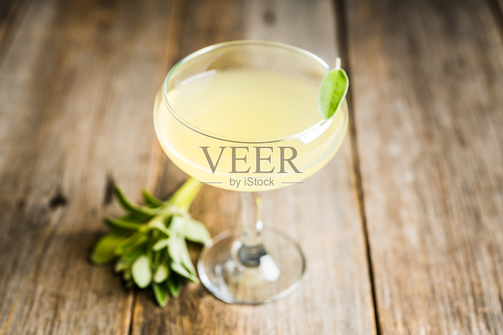 美味的鸡尾酒，柠檬酒和鼠尾草叶在乡村背景照片摄影图片