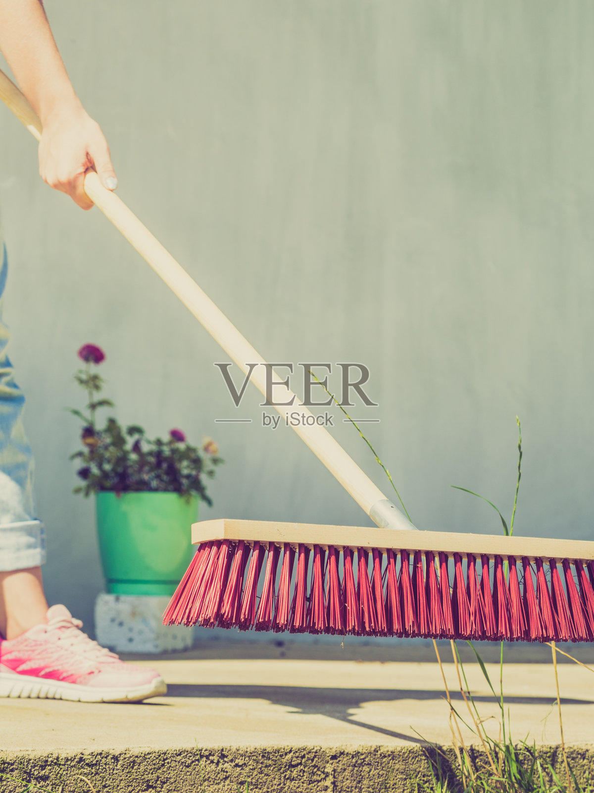 妇女用扫帚打扫后院庭院照片摄影图片