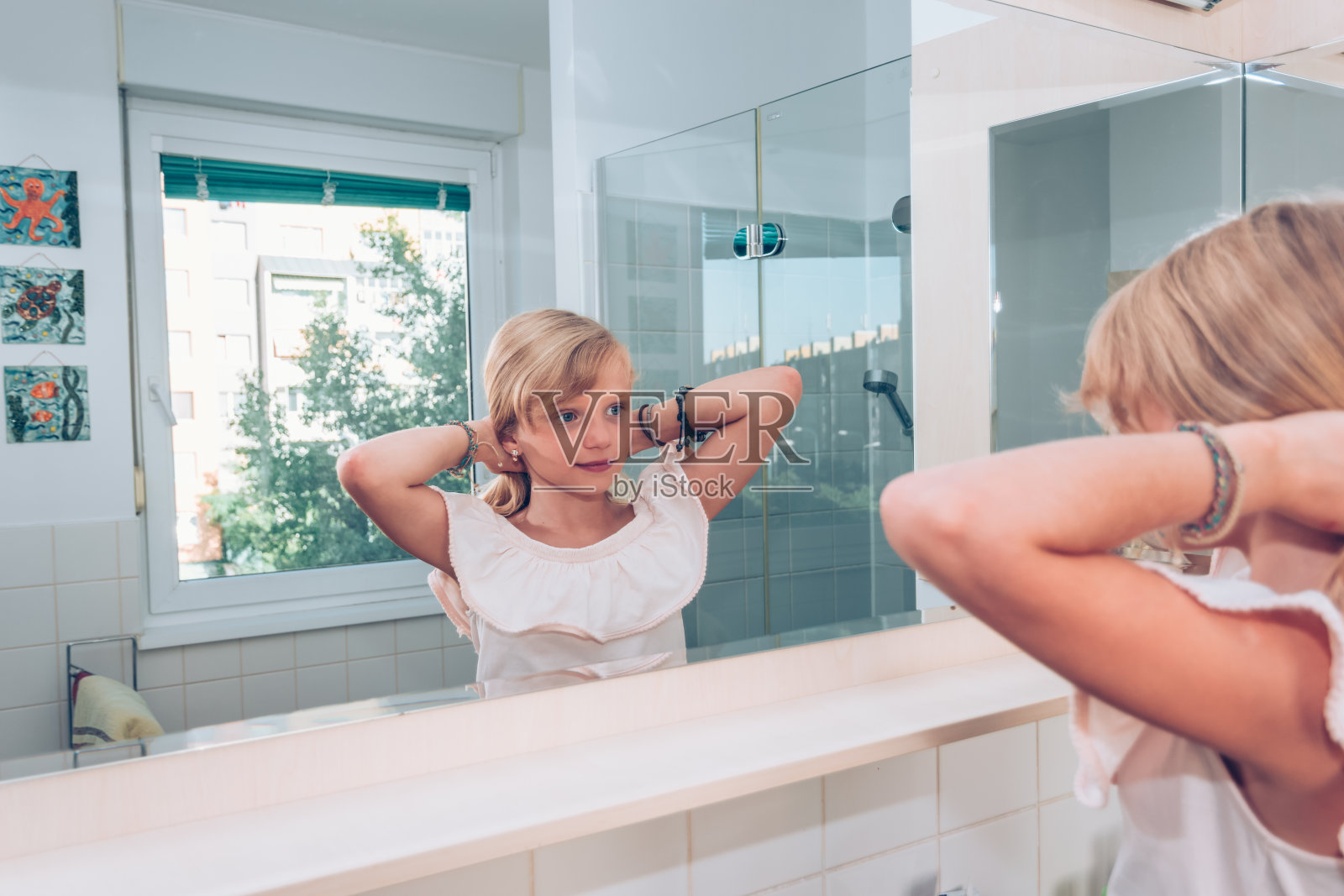 可爱的金发小孩在浴室的镜子前照片摄影图片