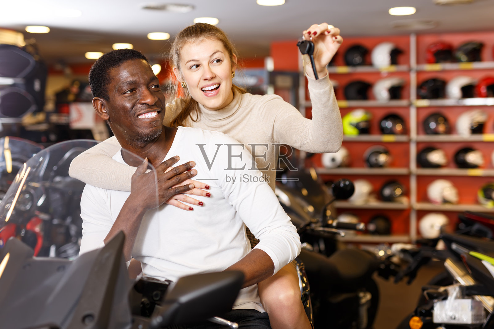 高兴的男人和女人摆姿势的新摩托车在商店照片摄影图片