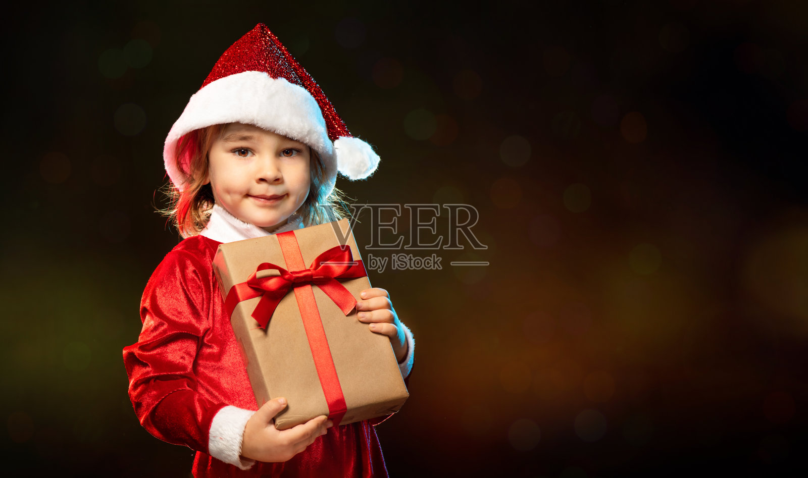 小可爱女孩的肖像在服装拿圣诞礼物盒照片摄影图片