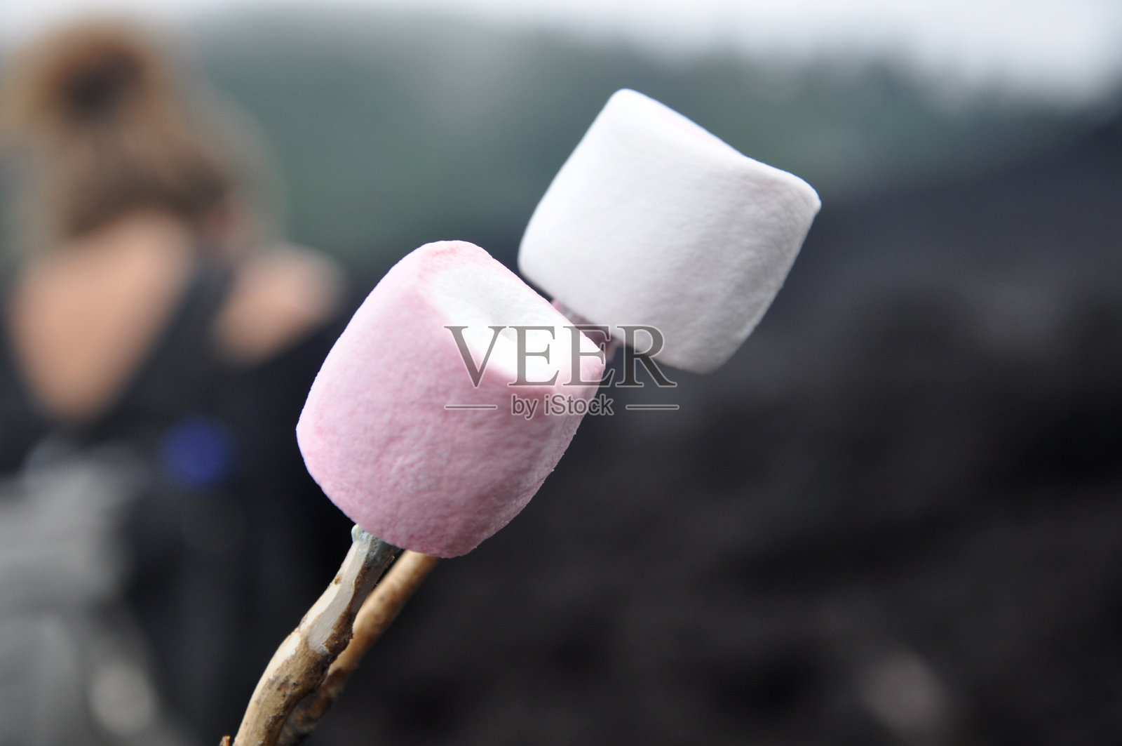 游客在中美洲危地马拉帕卡亚活火山的熔岩场烤棉花糖。照片摄影图片