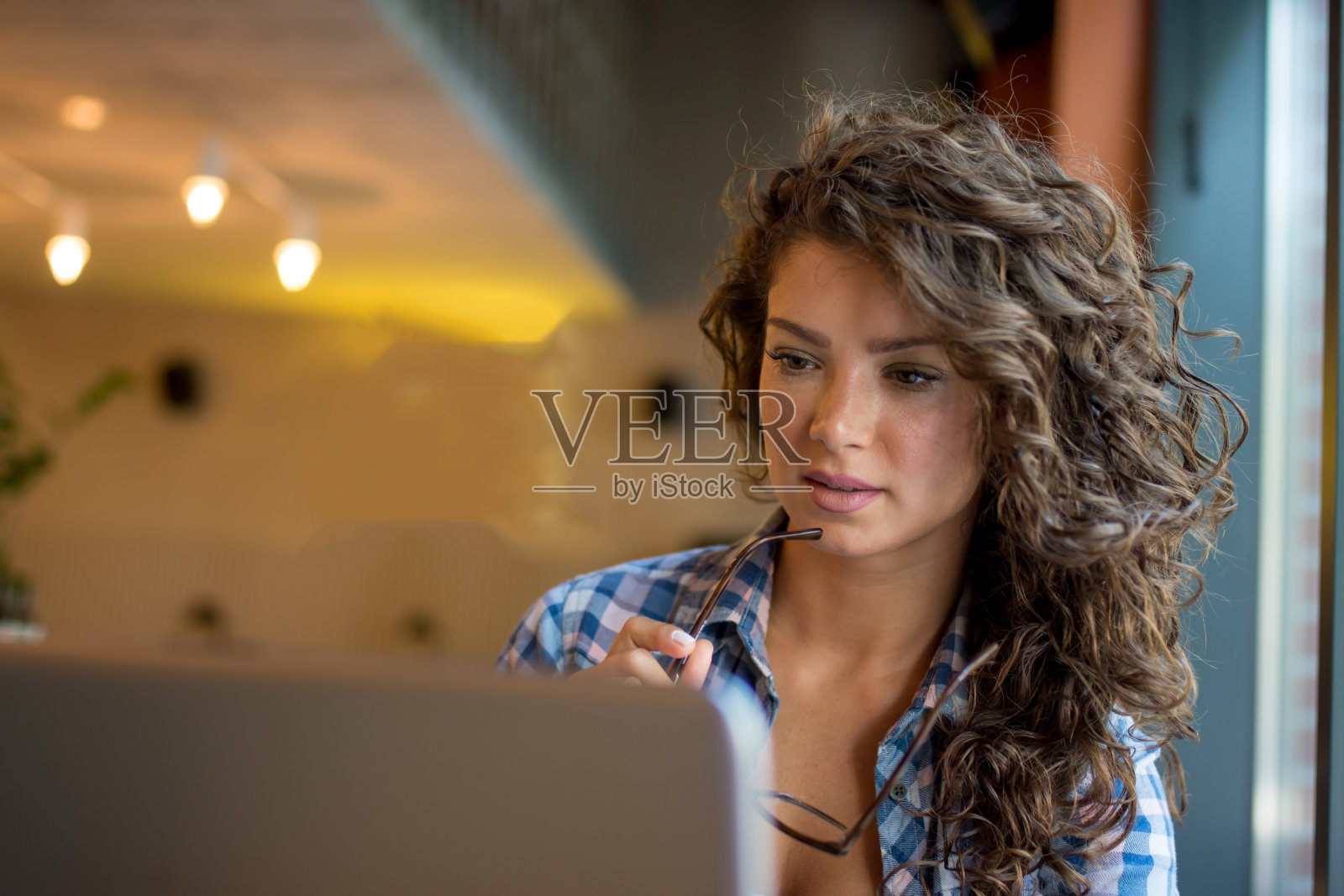 现代商业女性在咖啡店里使用笔记本电脑。照片摄影图片