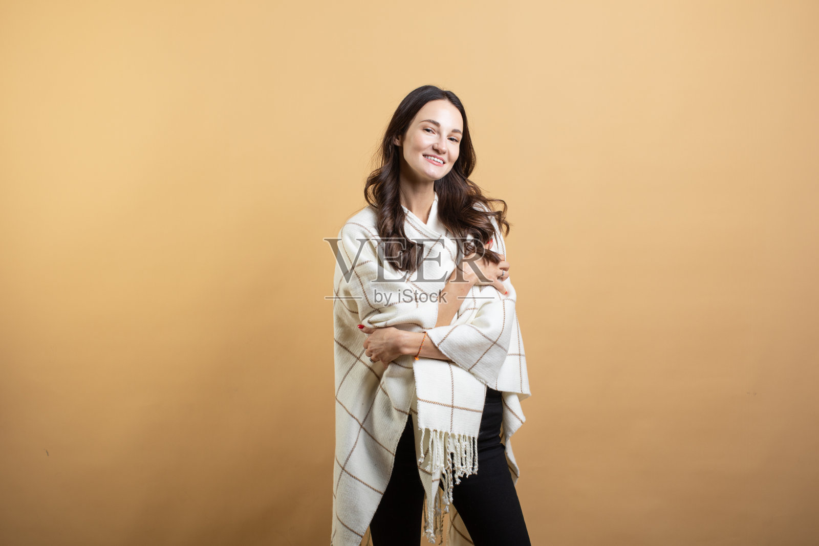 一个年轻美丽的女子穿着白色毛衣，在孤立的橙色背景下摆姿势，展示了不同的情绪照片摄影图片