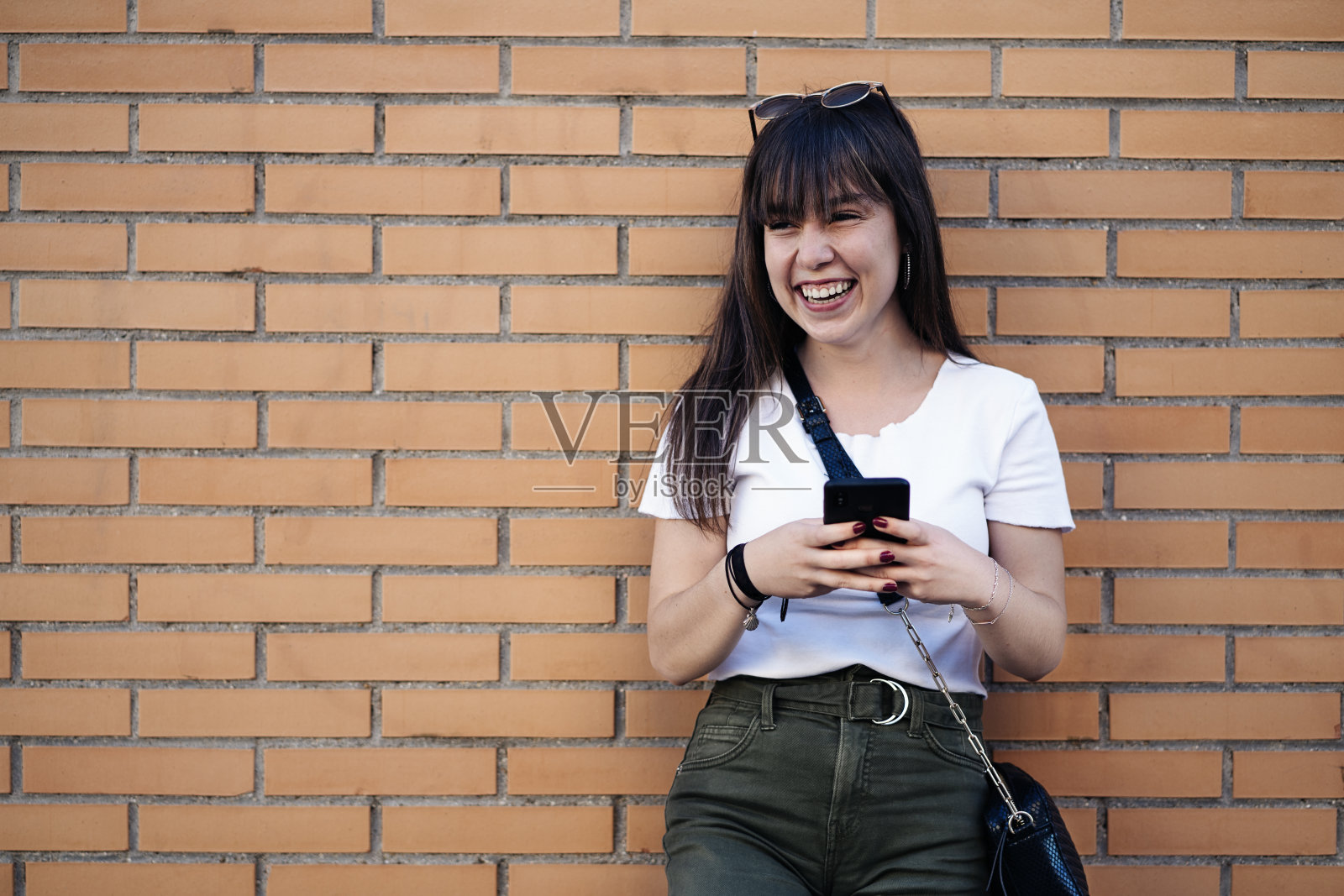 一个漂亮女人在街上用智能手机的肖像照片摄影图片