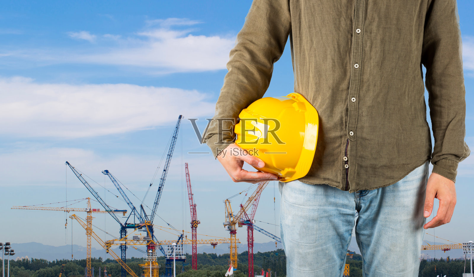 建筑工人在建筑工地前戴安全帽照片摄影图片