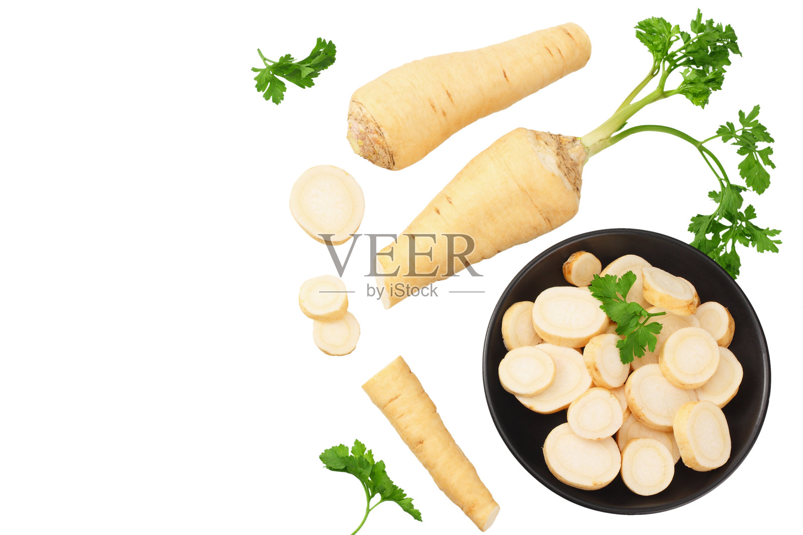 新鲜的欧芹根和欧芹片放在一个黑色的盘子里，孤立在白色的背景上。俯视图照片摄影图片