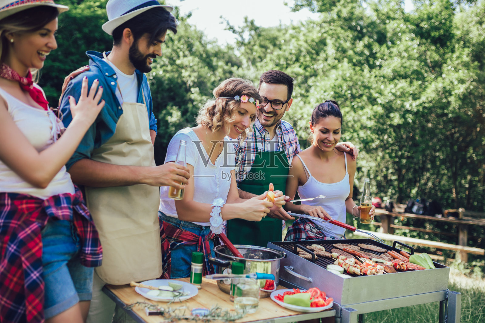 年轻的朋友们享受烧烤的乐趣。照片摄影图片