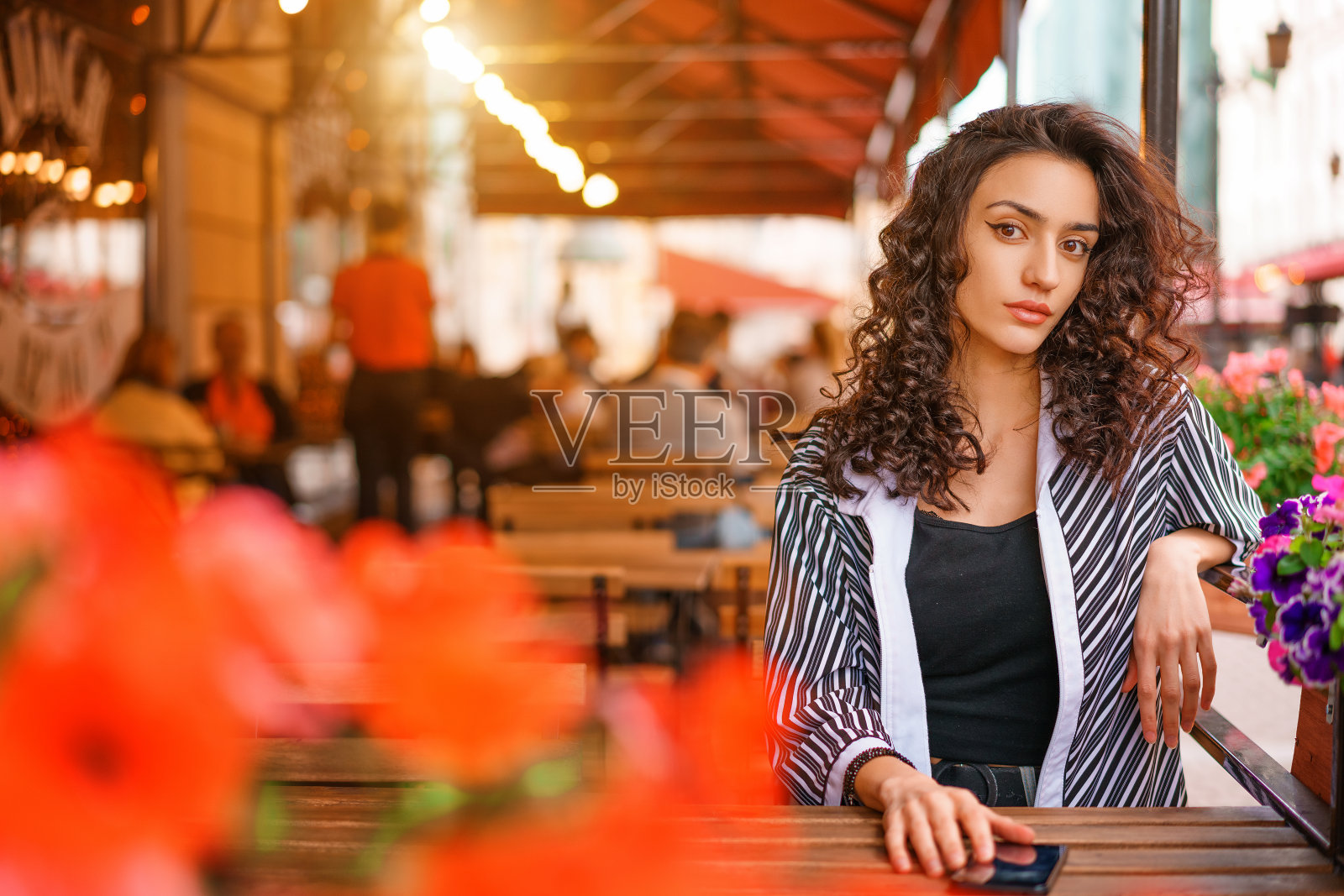 一个美丽的年轻女人的肖像与卷头发的特写。照片摄影图片