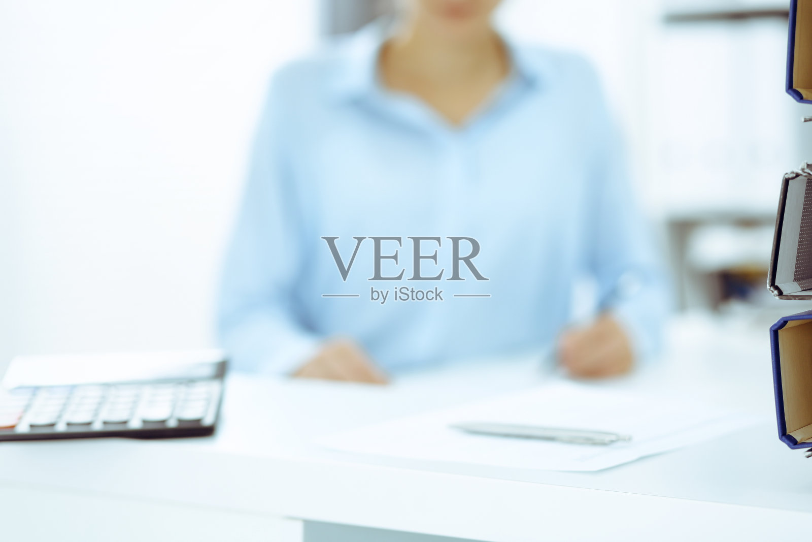 计算器和装订纸等着由女商人或簿记员在模糊中处理。内部审计和税务概念。照片摄影图片