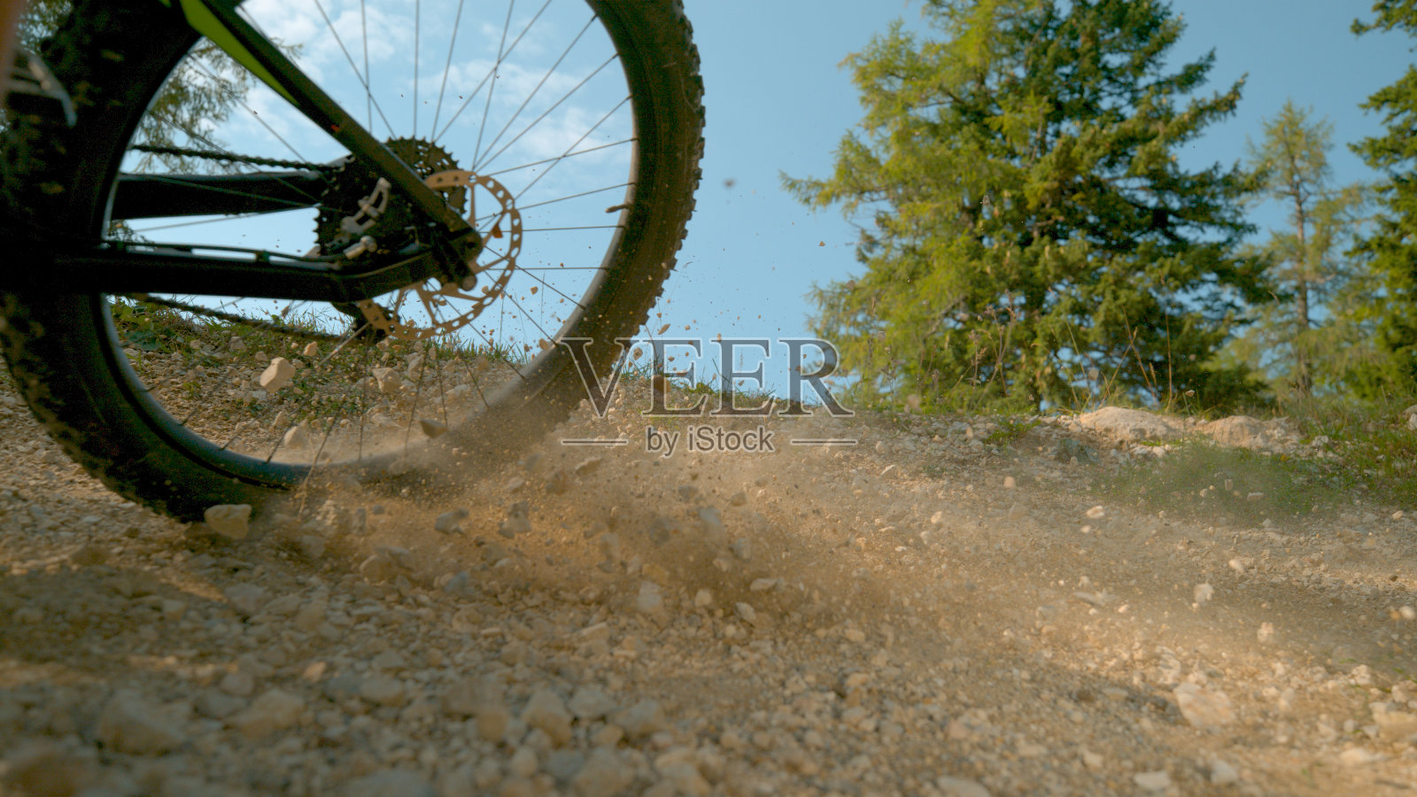 近景:无法辨认的自行车煞车，而加速沿砾石轨道照片摄影图片