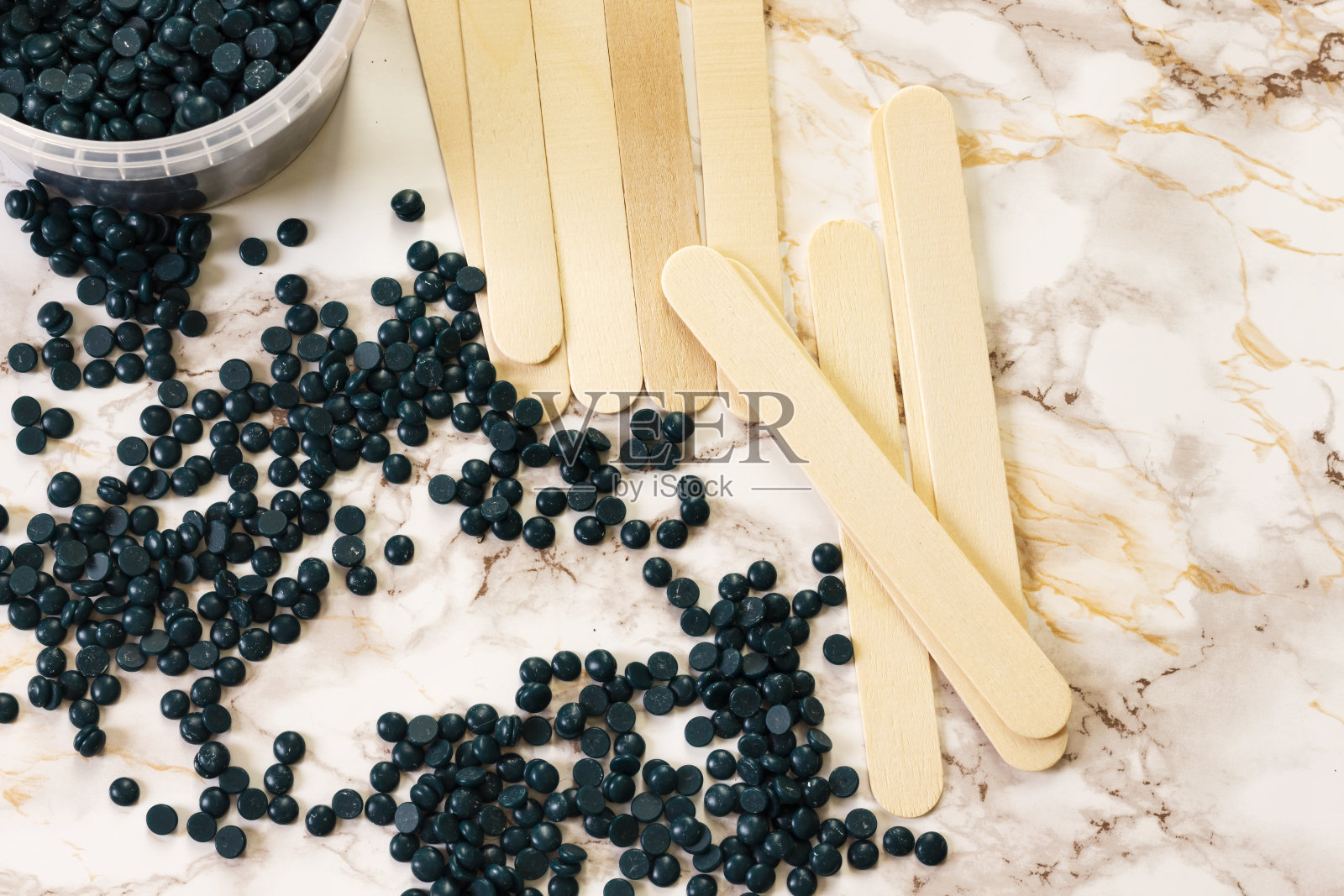 脱毛珍珠蓝实心蜡豆和木棒在大理石背景上照片摄影图片