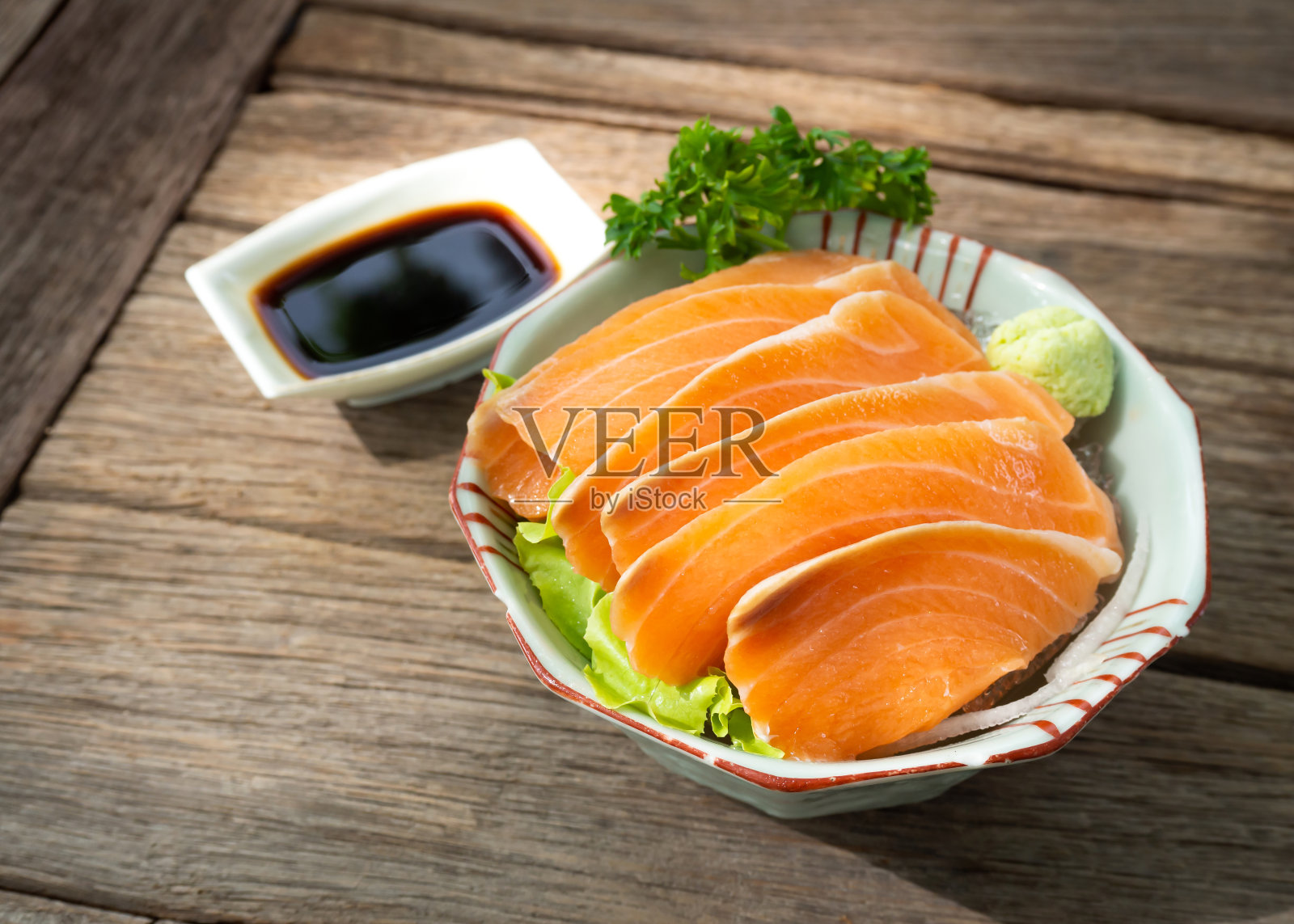 三文鱼刺身与酱油和芥末一起放在木桌上。日本的食物。照片摄影图片