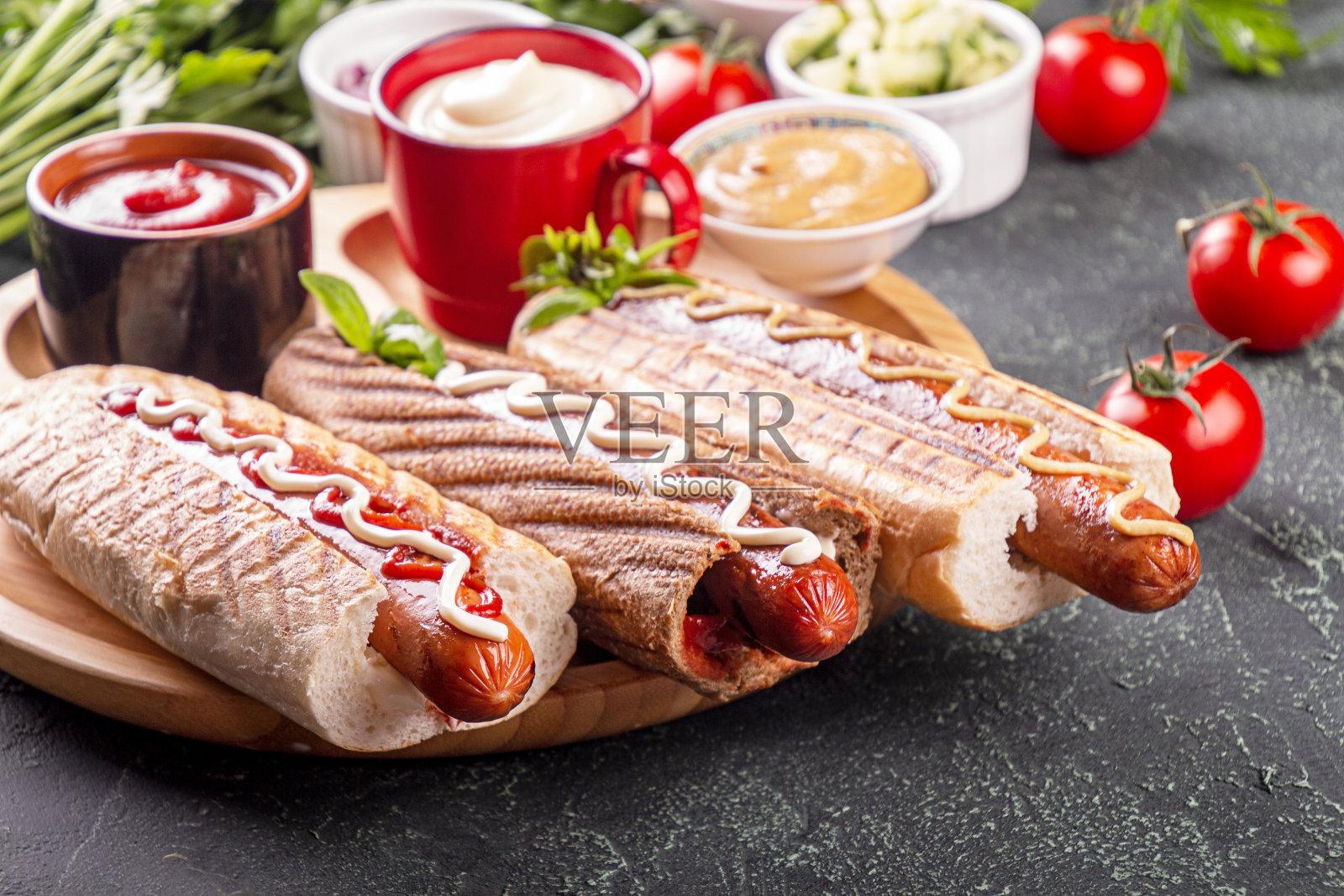 热狗，蔬菜和酱汁的黑色背景。快餐，美国的额外食品照片摄影图片