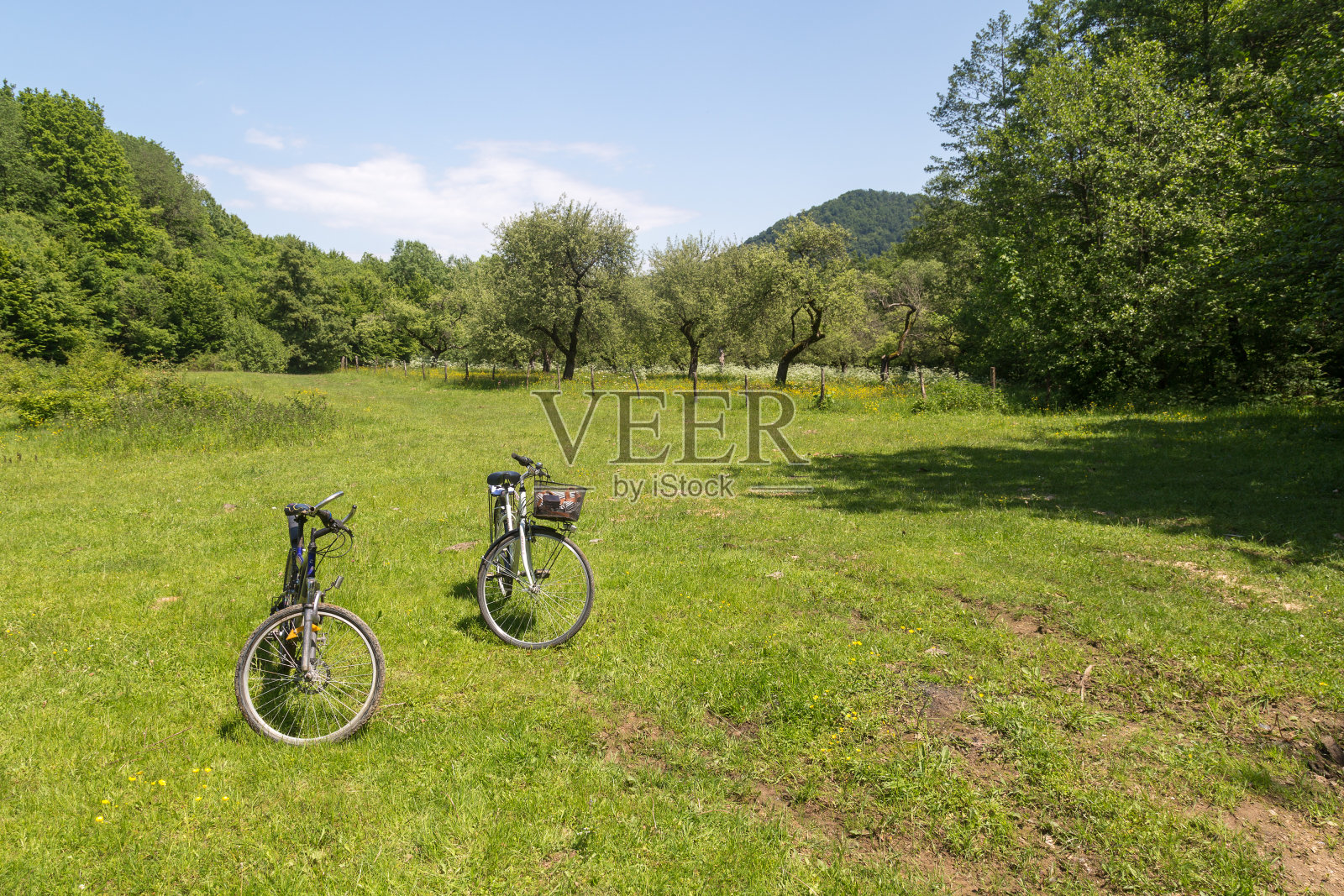 一对夫妇的自行车站在山区乡村的草地上。Wonderlust旅行系列。照片摄影图片