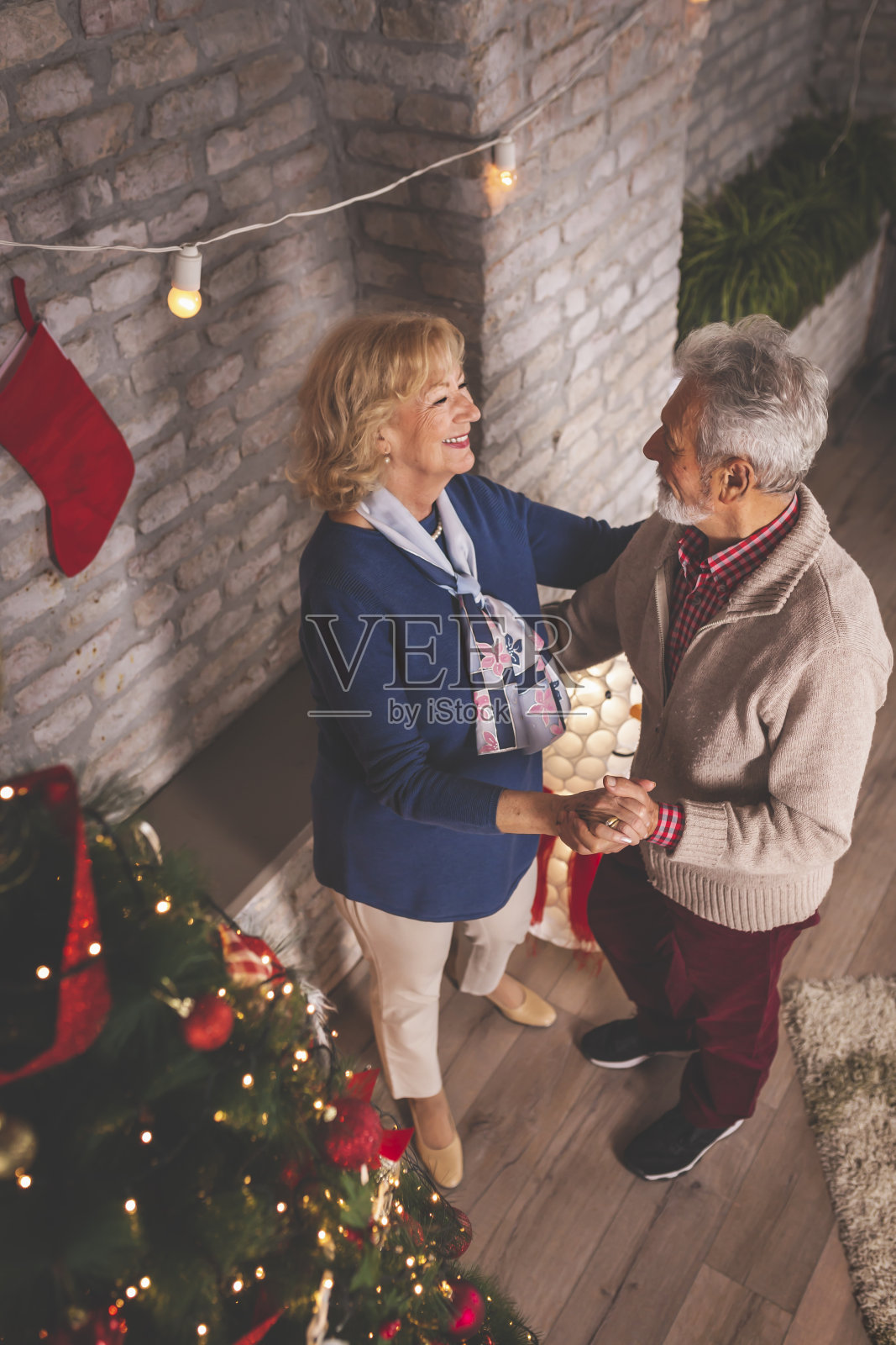 一对高年级情侣在圣诞树旁跳舞照片摄影图片