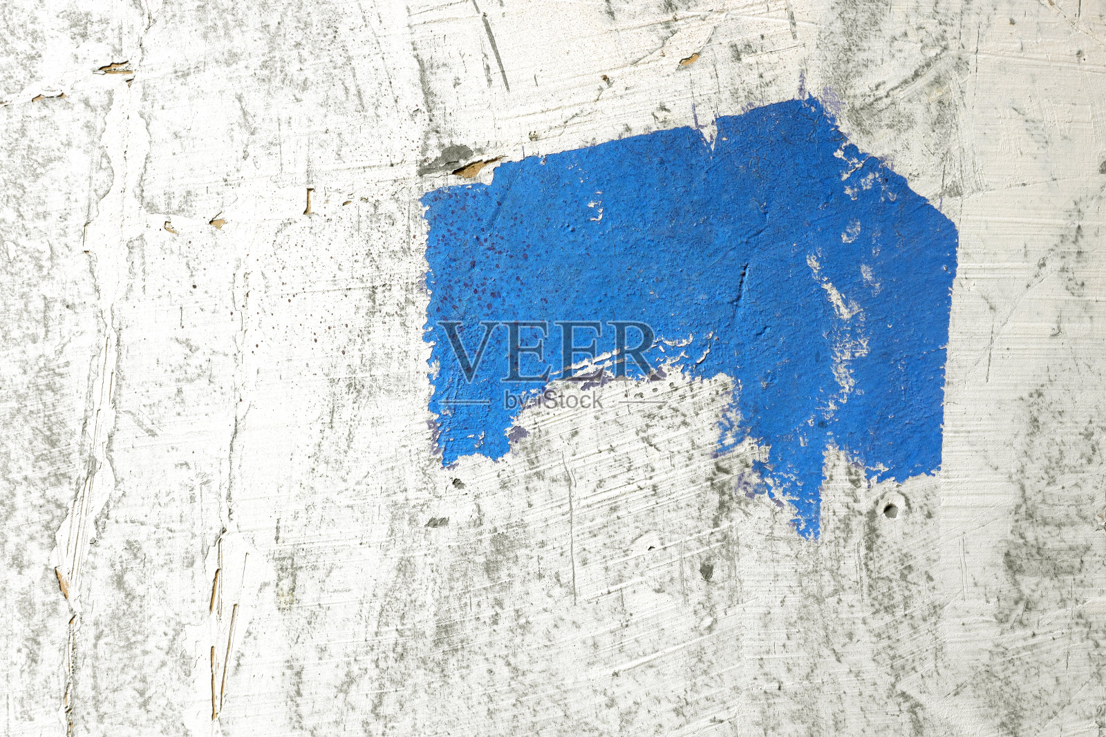 粗糙的彩色画笔在白色粗糙的墙壁上。白色墙壁上的蓝色画笔。照片摄影图片