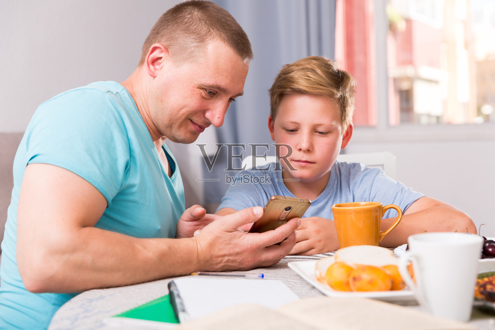 一个男人和他的儿子一起玩手机照片摄影图片