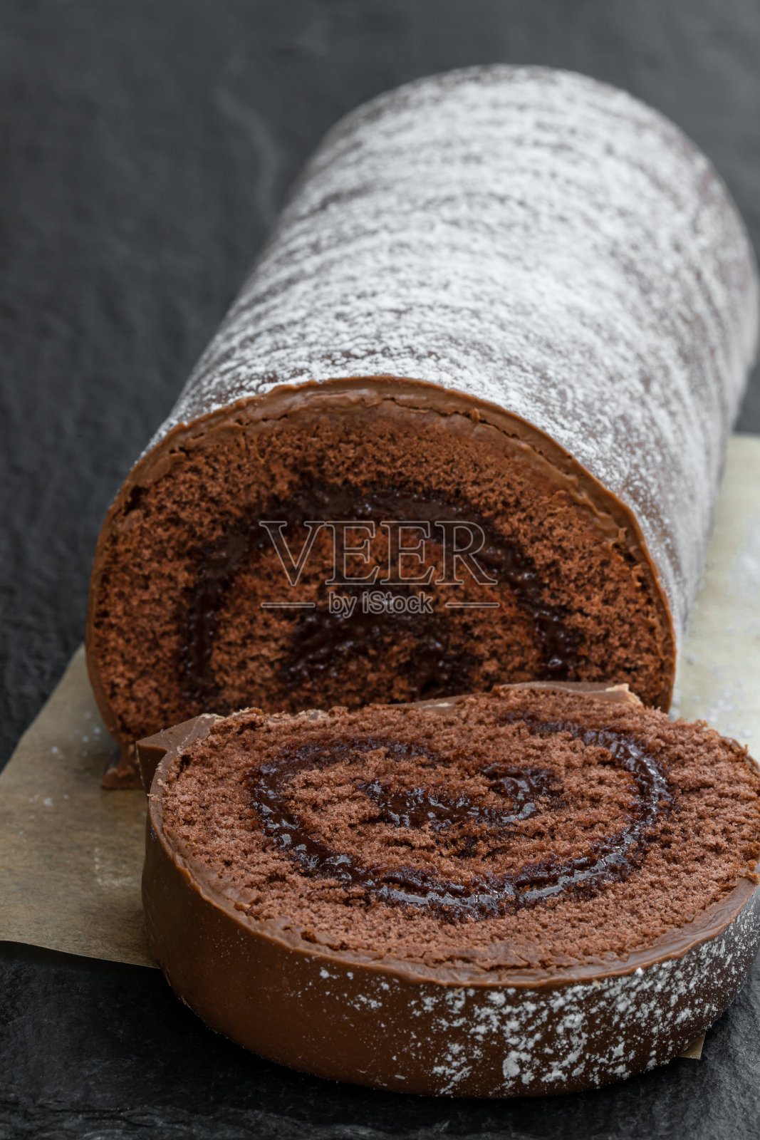 巧克力圣诞蛋糕涂上牛奶巧克力在黑色的石头背景照片摄影图片