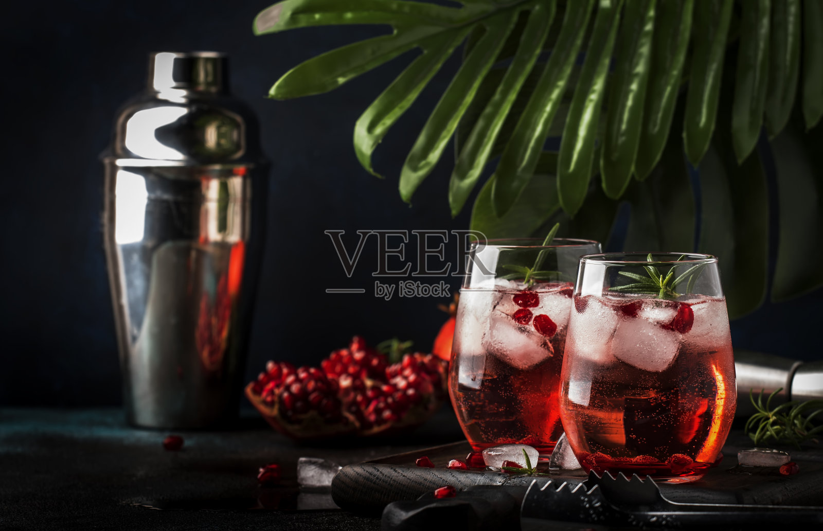 红色鸡尾酒伏特加石榴汁，冰和迷迭香，酒吧工具，蓝色吧台背景，俯视图照片摄影图片