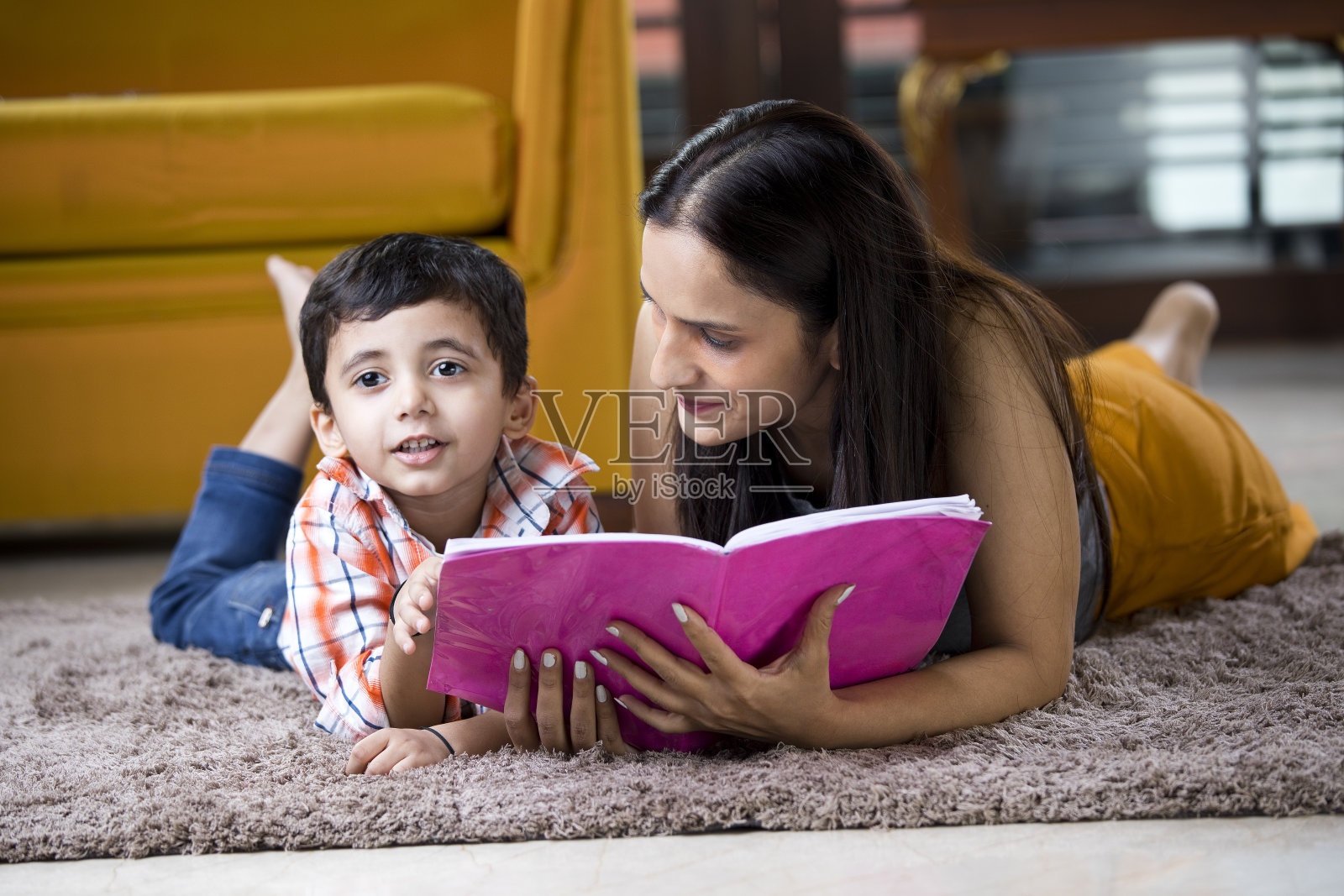 惊讶的妈妈用儿子写的书照片摄影图片