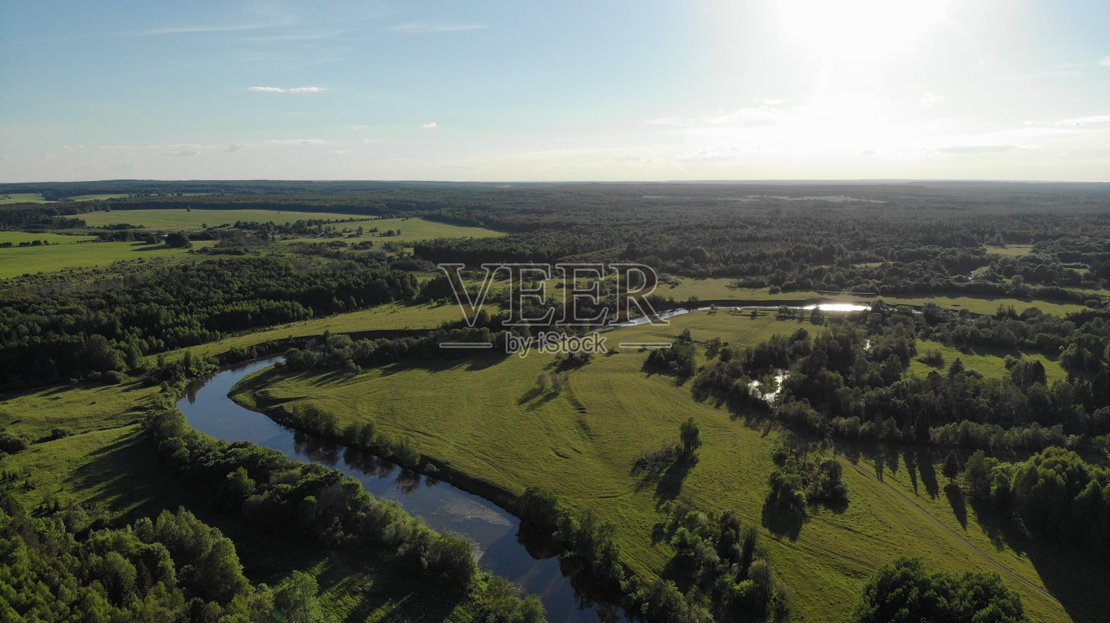 俯视图蜿蜒的小河流过绿色的草地照片摄影图片