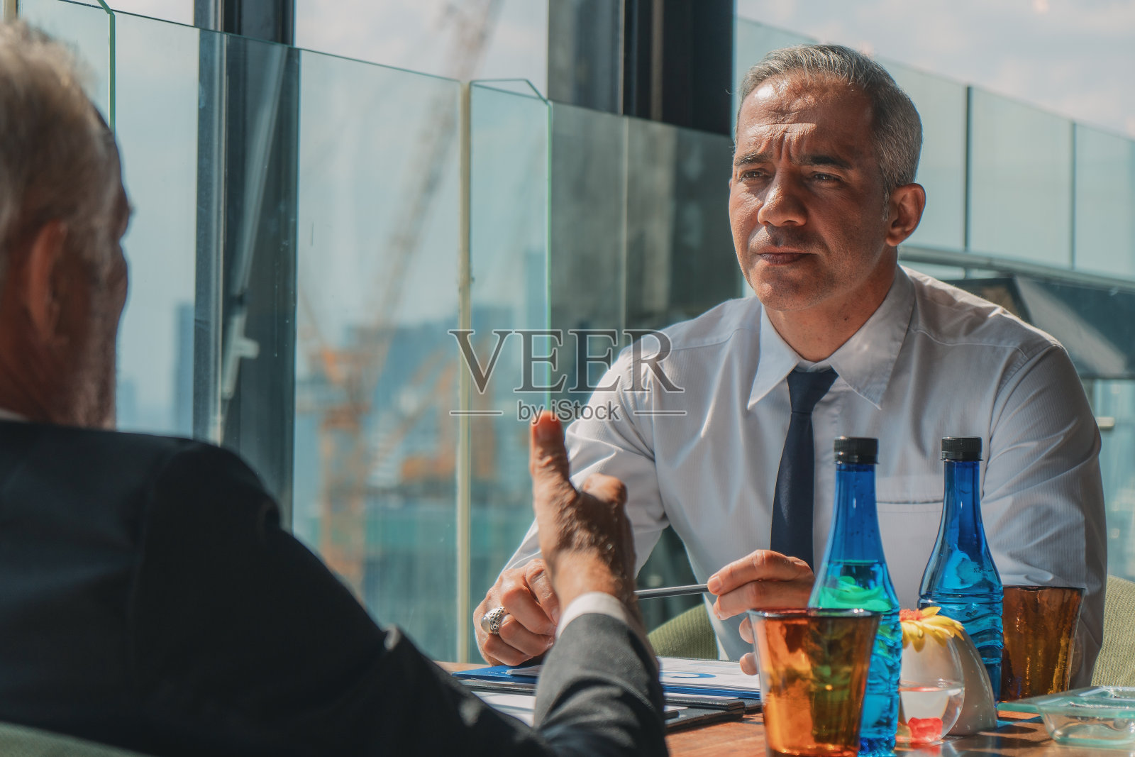 一位白发商人在行政酒廊与同事谈生意照片摄影图片