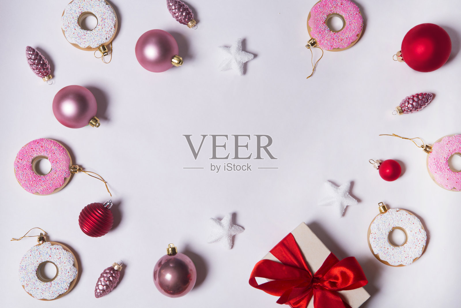 纸白色背景与圣诞装饰球，甜甜圈，礼物和星星。平躺，俯视图。圣诞贺卡的观念。照片摄影图片