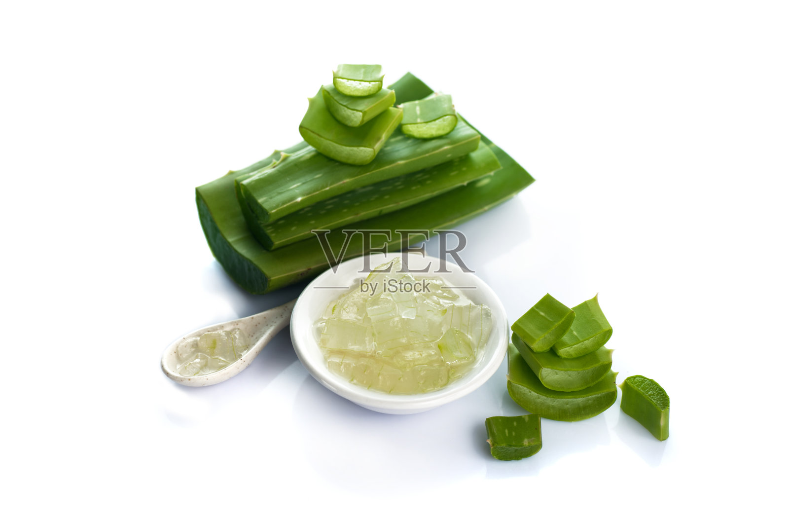 在白色背景的碗中放入芦荟叶和芦荟凝胶片。芦荟是一种非常有用的草药，用于皮肤护理和头发护理。照片摄影图片