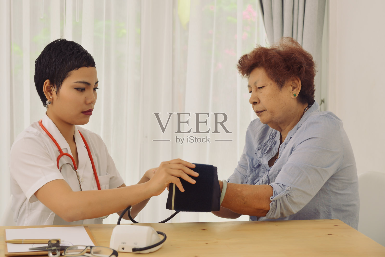 亚洲医生检查她的病人女性在办公室。照片摄影图片