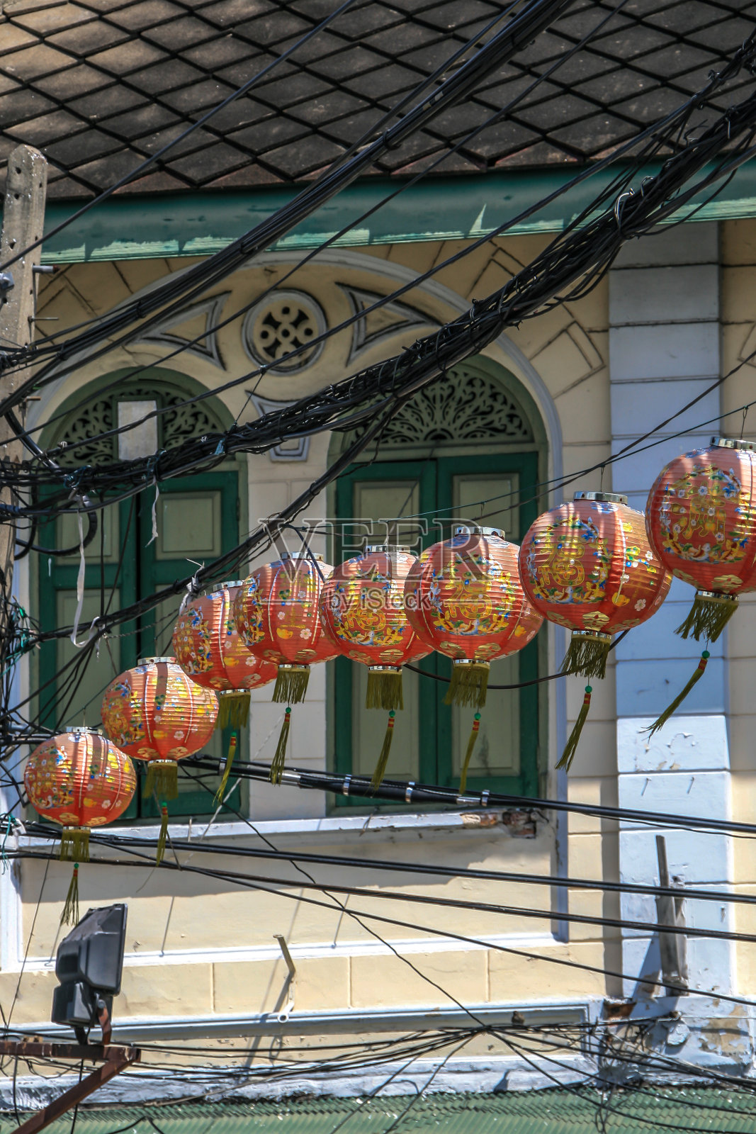 中国灯笼挂在街对面的电缆上。照片摄影图片