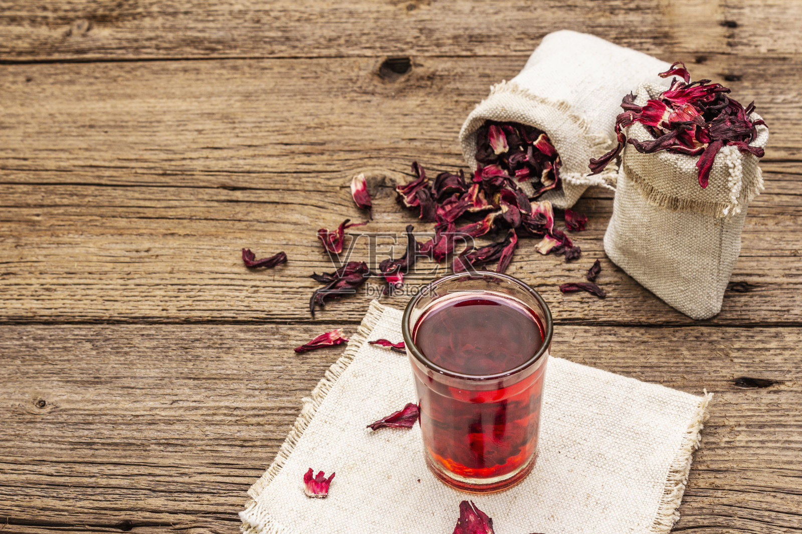 热芙蓉茶。干花瓣，亚麻麻袋。健康食品和自我保健理念。旧木板背景照片摄影图片