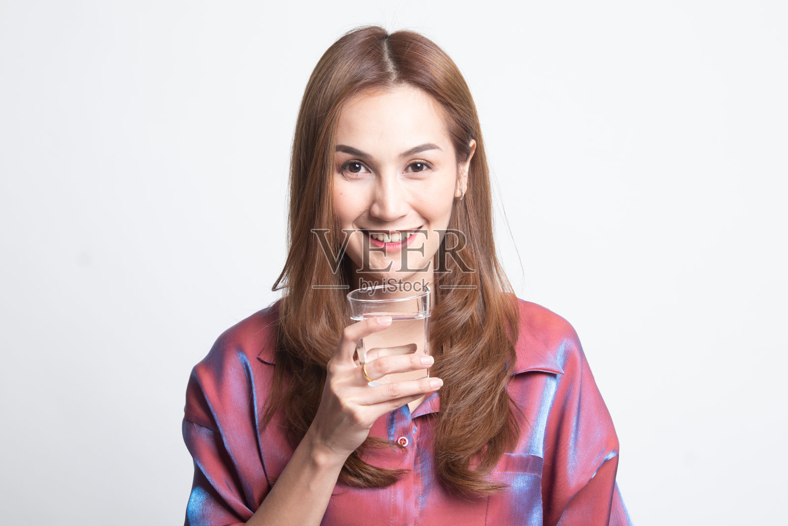 年轻的亚洲女人拿着一杯饮用水。照片摄影图片