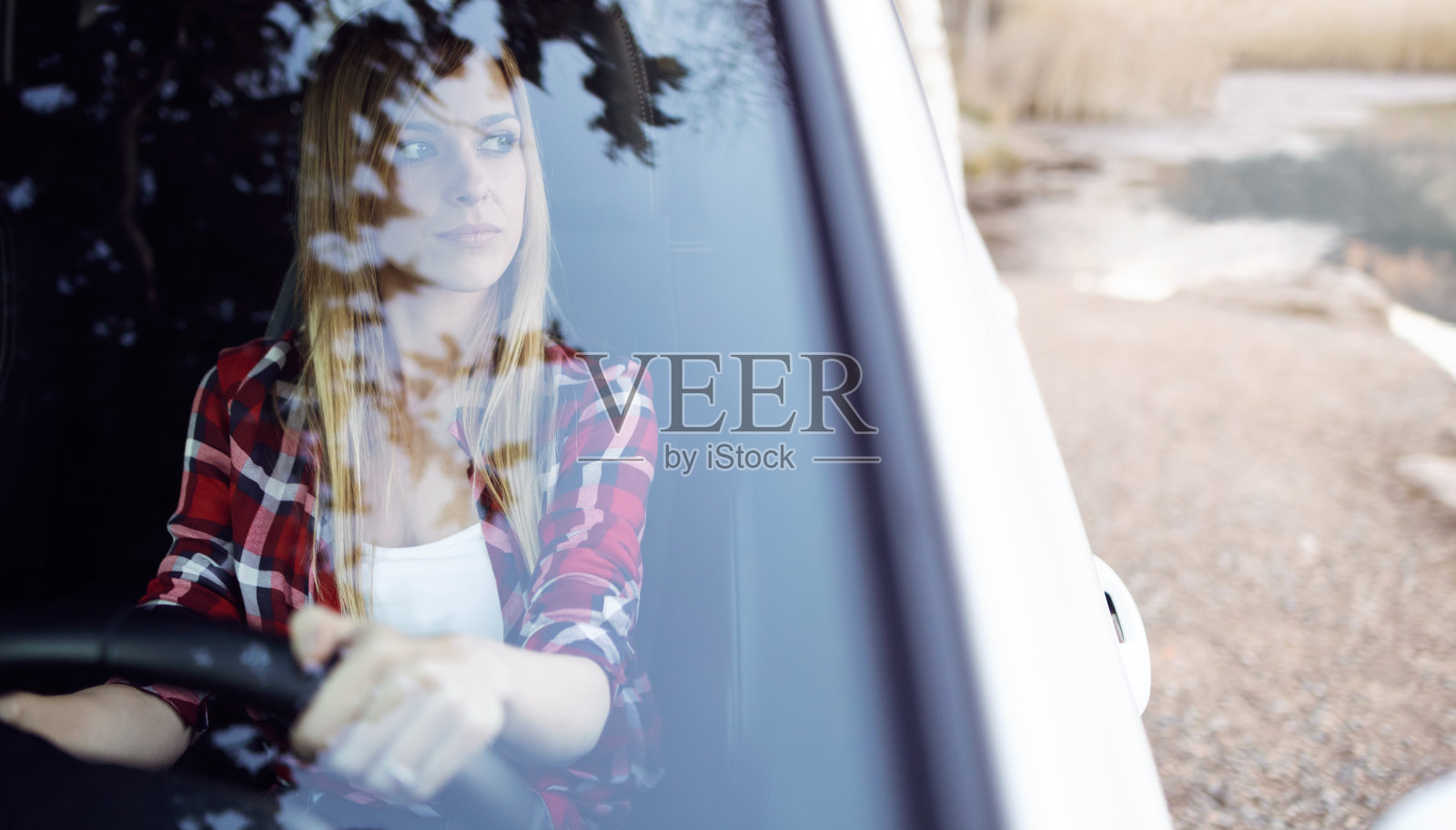 自信的年轻女子从车上看和享受自然景观。照片摄影图片