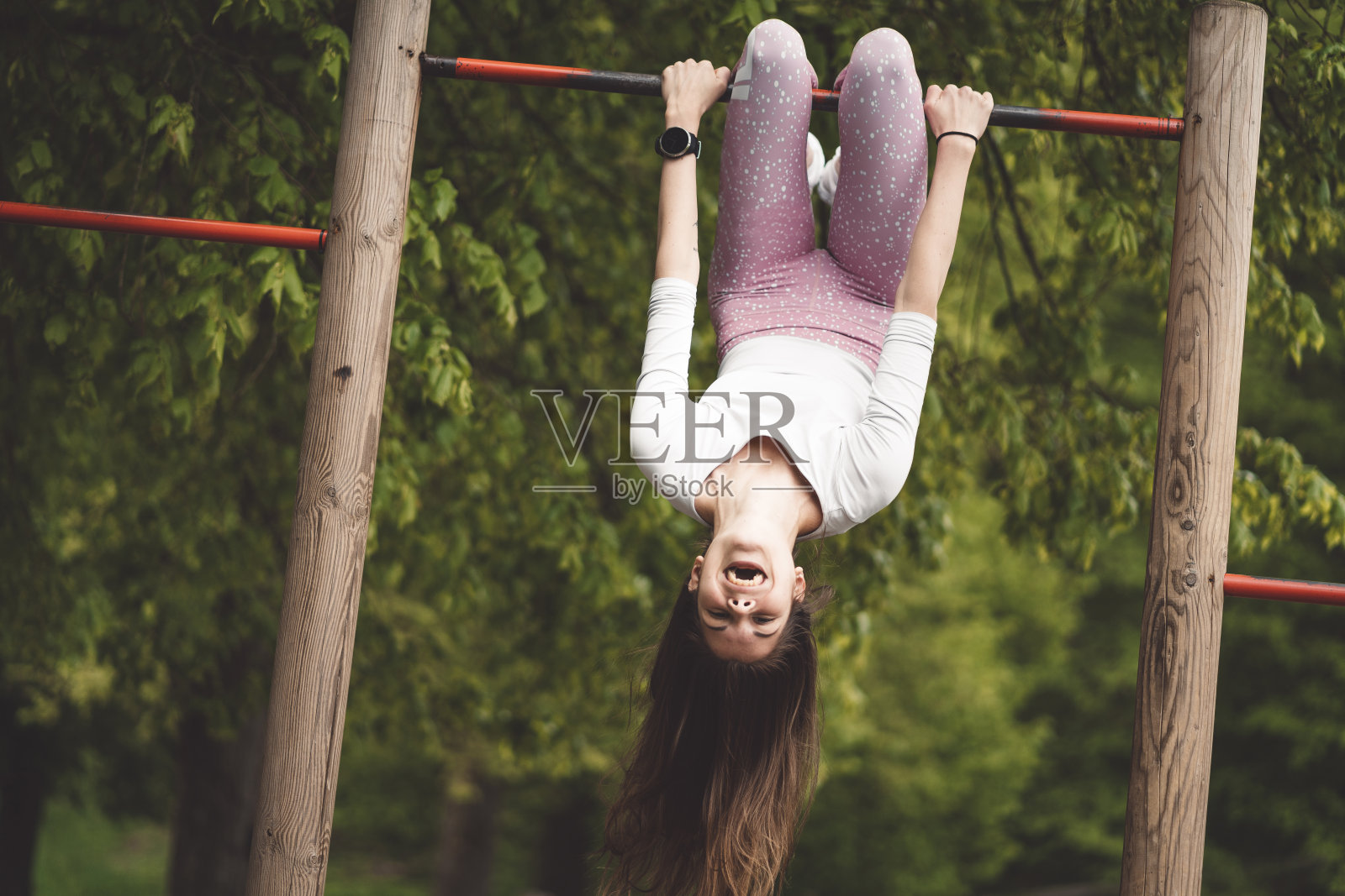 生活颠倒-女人倒挂在杆子上照片摄影图片