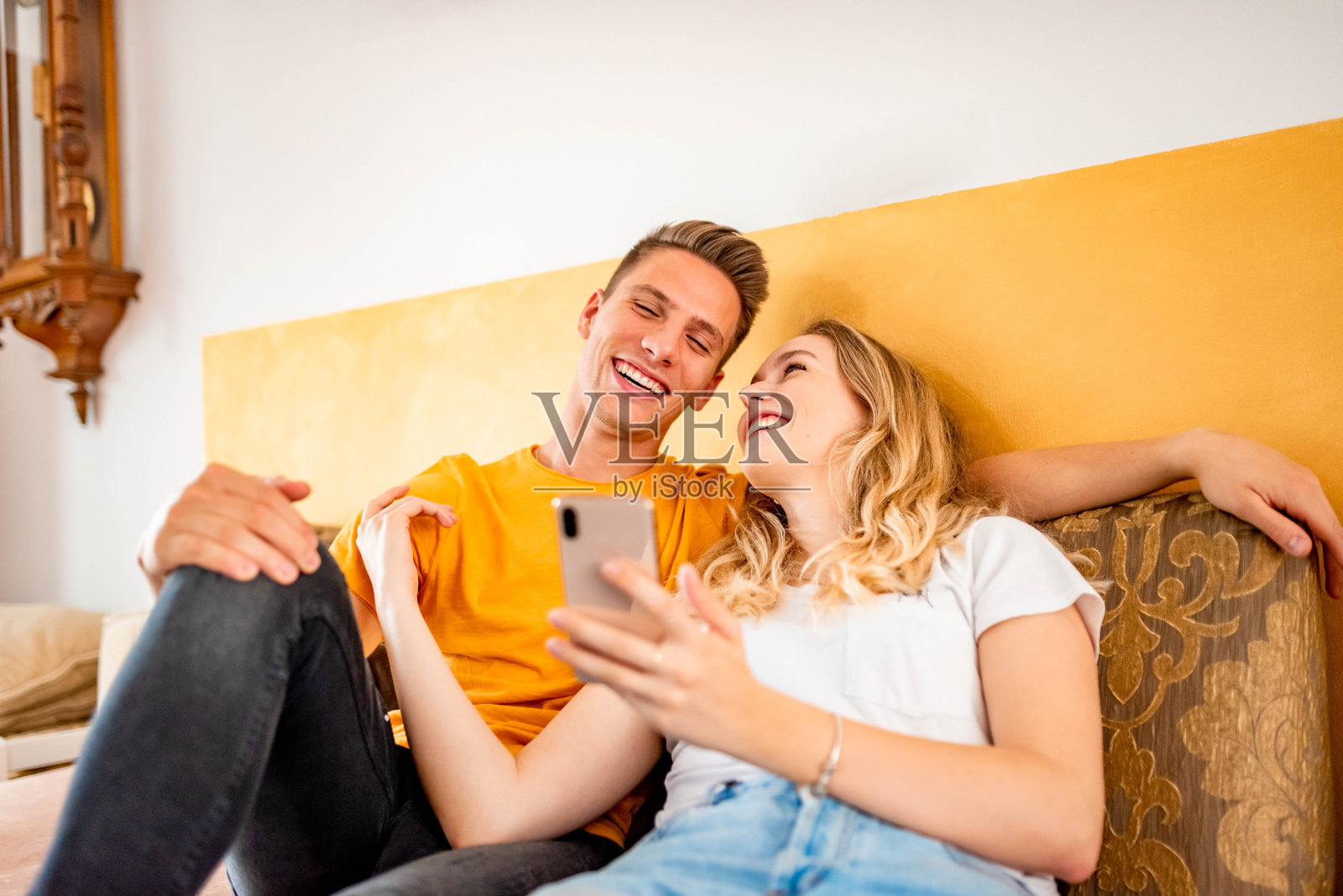 一对年轻夫妇在沙发上玩手机照片摄影图片